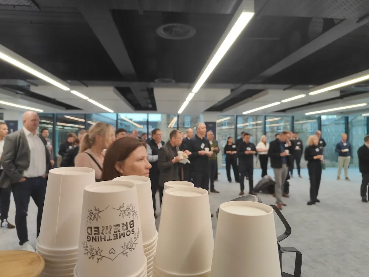 Staff gathering around coffee bar for corporate event launch in Edinburgh