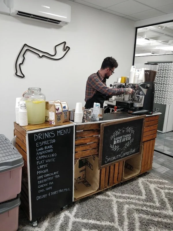 Barista preparing artisan latte at office coffee bar
