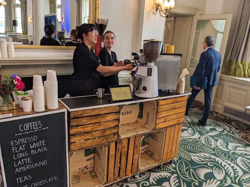 Espresso barista preparing drinks at conference coffee bar