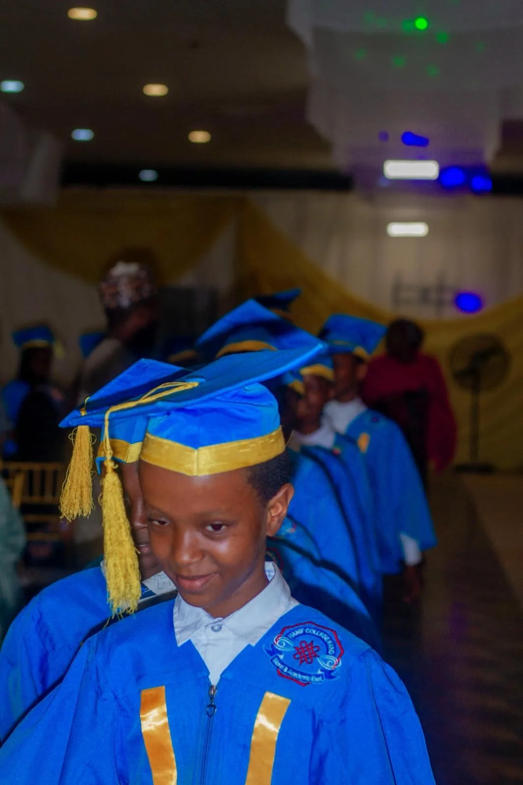 Young student in a blue graduation cap and gown