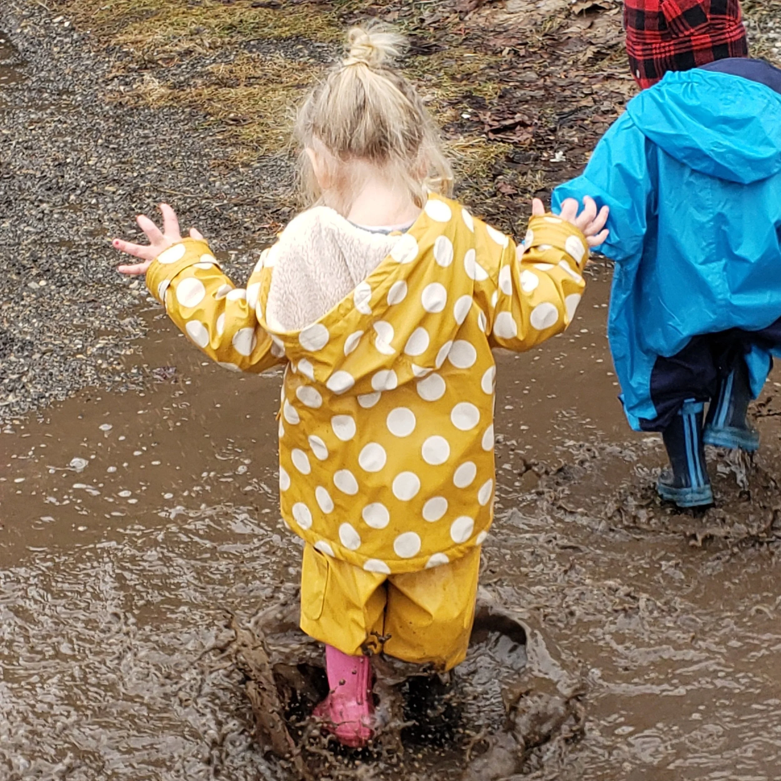 little girl at a daycare in ontario playing in the mud