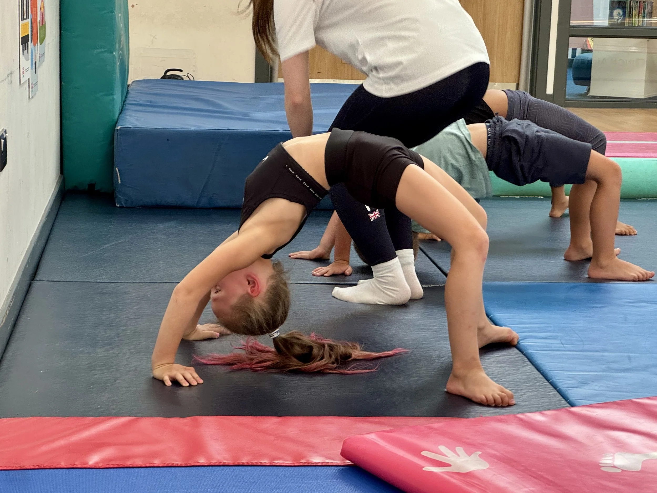 GymnaX children learning gymnastics bridge