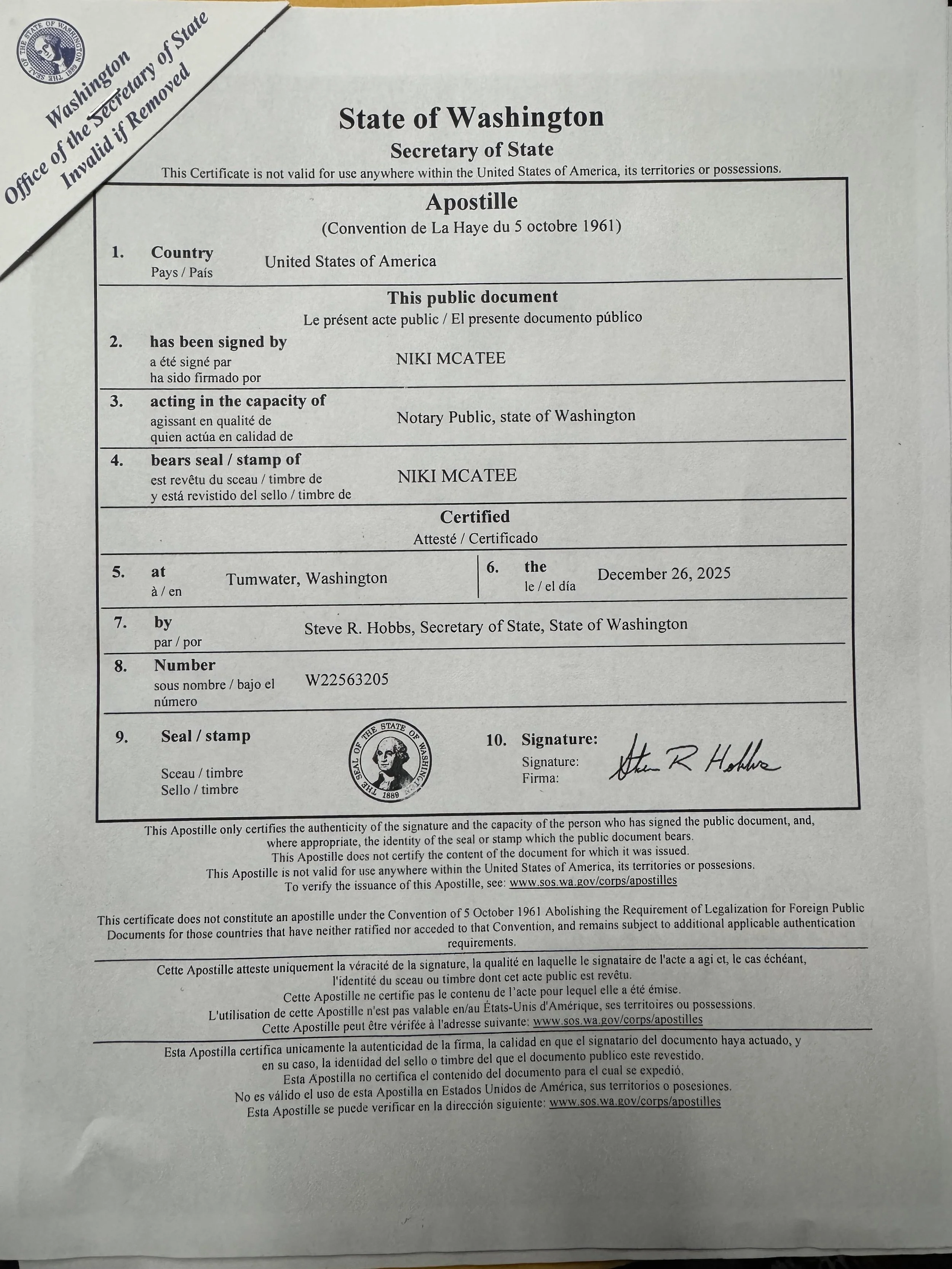 A public apostille certificate from the State of Washington, issued in Tumwater, dated December 26, 2025, signed by Steve R. Hobbs, with official seal and stamp, certifying the signature of Niki Mcatee on the document.