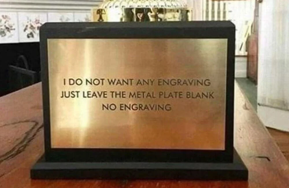 Sign on a metal plaque that says 'I DO NOT WANT ANY ENGRAVING JUST LEAVE THE METAL PLATE BLANK NO ENGRAVING'.