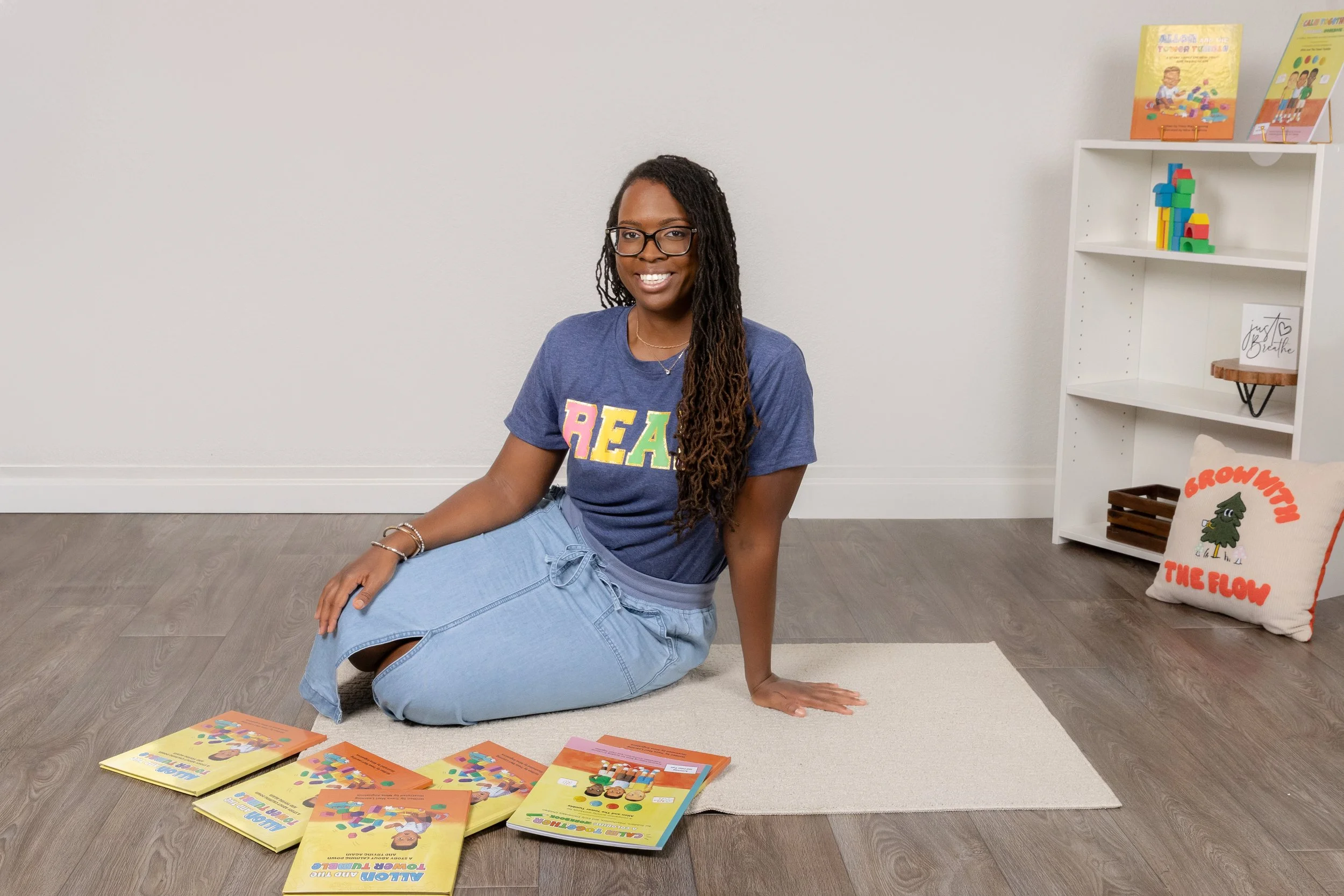 African-American female children's book author sitting on a rug with her books during her personal branding session