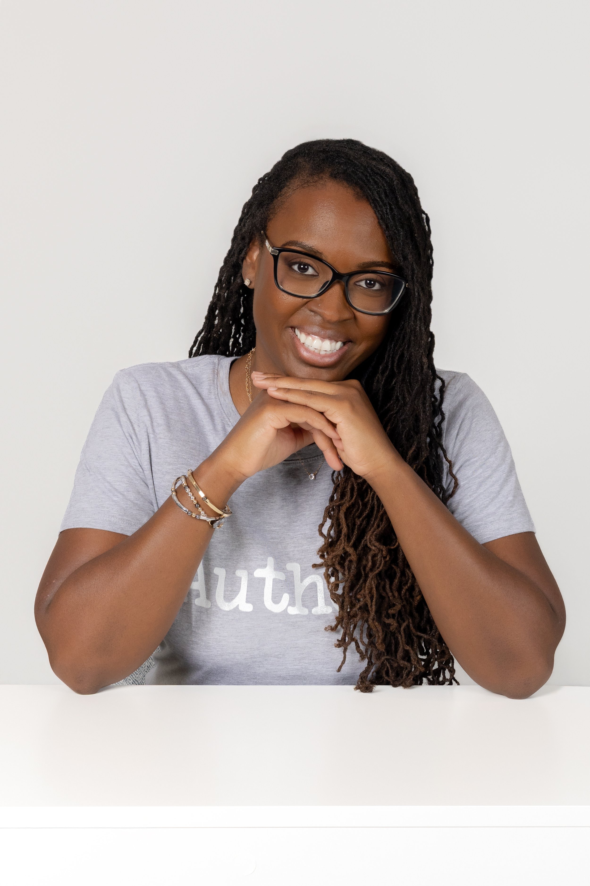 Professional headshot of an African-American female children's book author smiling at the camera during her personal branding session