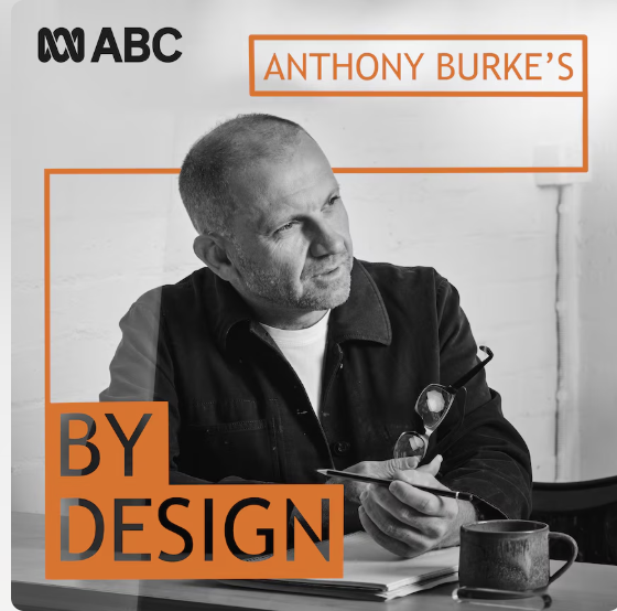 Promotional image of Anthony Burke sitting at a desk holding a pen and glasses, includes a text overlay with the ABC logo and the words 'Anthony Burke's by design'