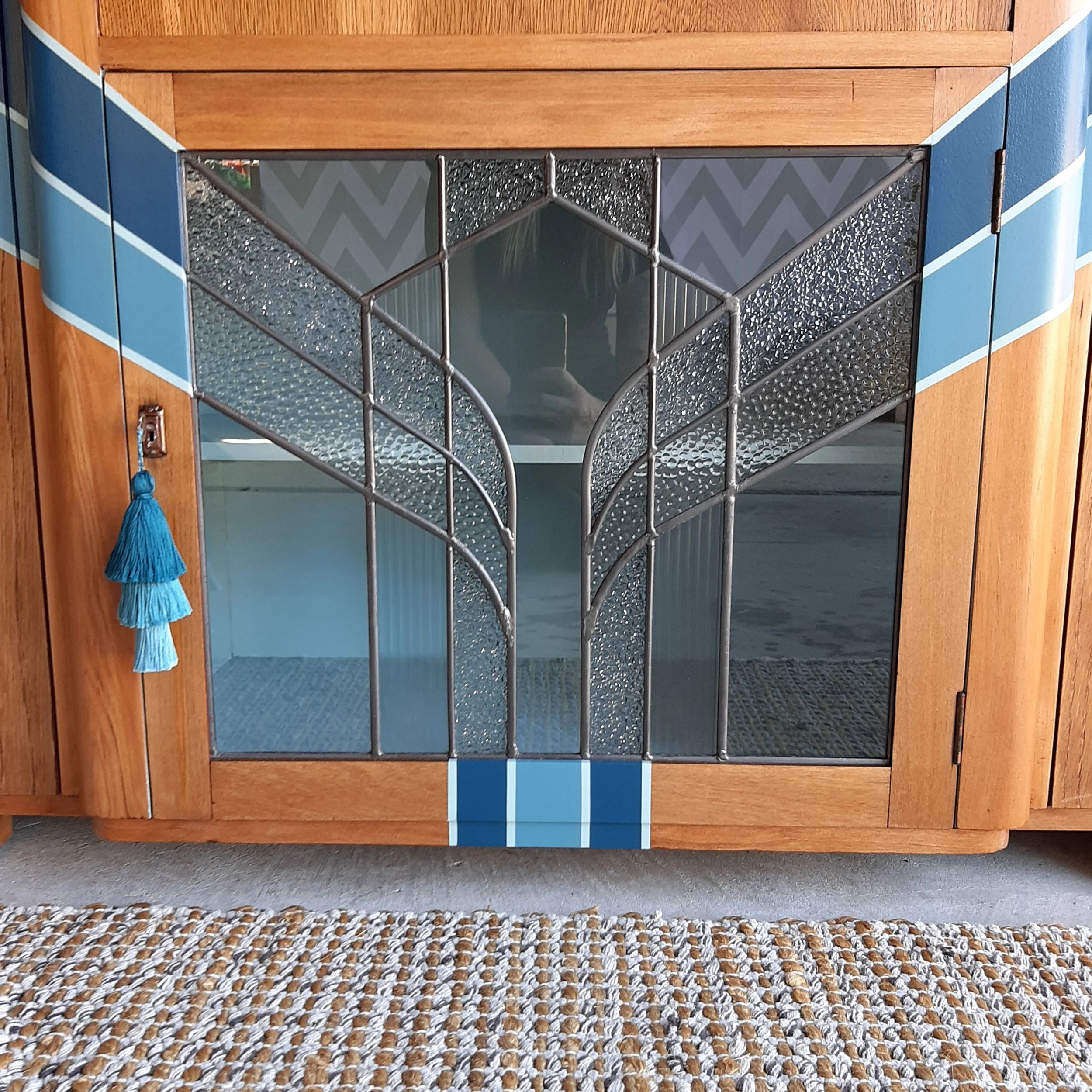 Upcycled art deco sideboard cabinet with mirror and a new customised leadlight front designed and made by me. Built new leadlight panel for the front middle cabinet, sanded off old shellac, painted new design, varnished