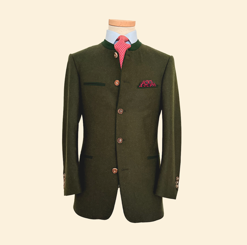 Veste traditionnelle masculine verte avec boutons en métal, poche à la poitrine avec une pochette rose à motifs, chemise blanche et cravate rose à motifs