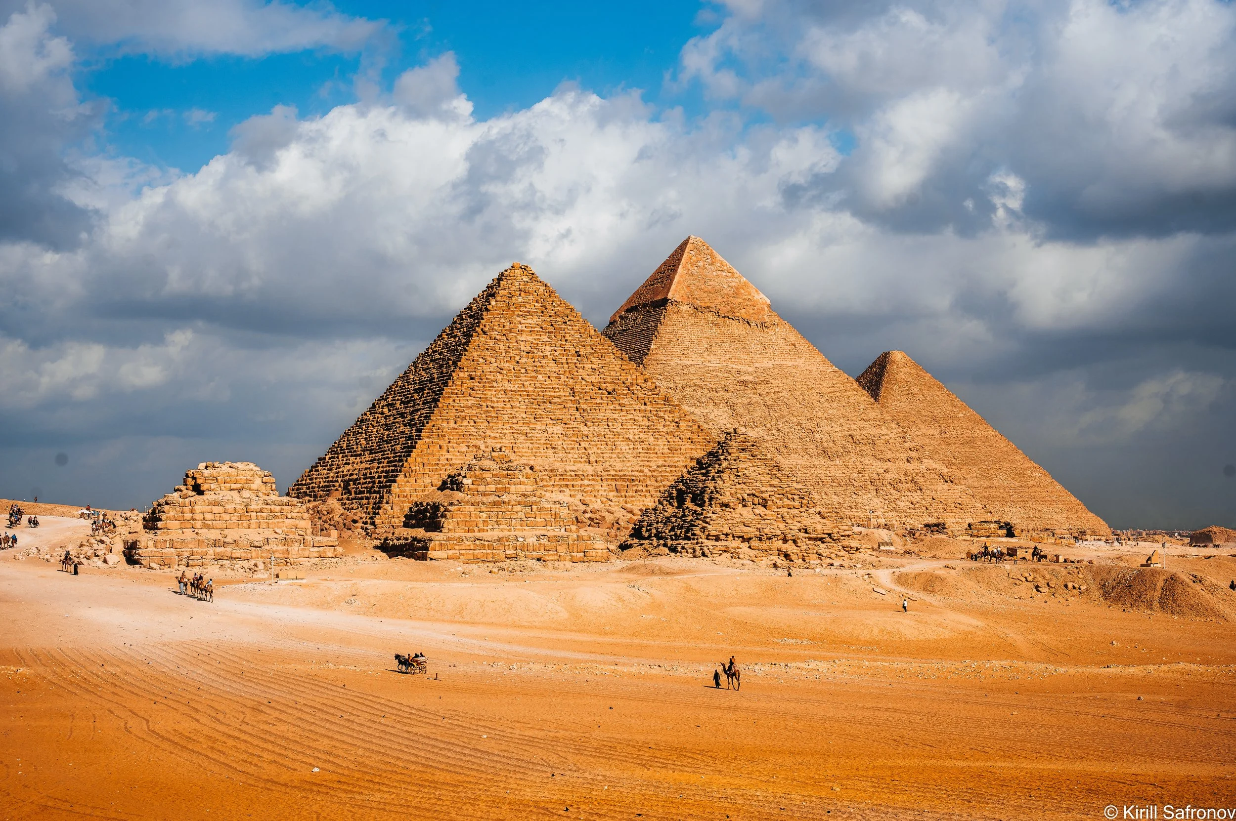 Photo of the Pyramids of Giza in the Egyptian desert under a partly cloudy sky, showcasing one of Egypt’s most iconic ancient landmarks near Cairo.