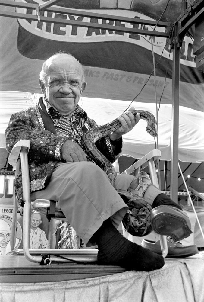  This is Petey with a Python on a stage in front of the Sideshow. He was trying to entice the locals to go inside the tent to see the sideshow acts. Petey was very shy. I never heard him speak a single word. 