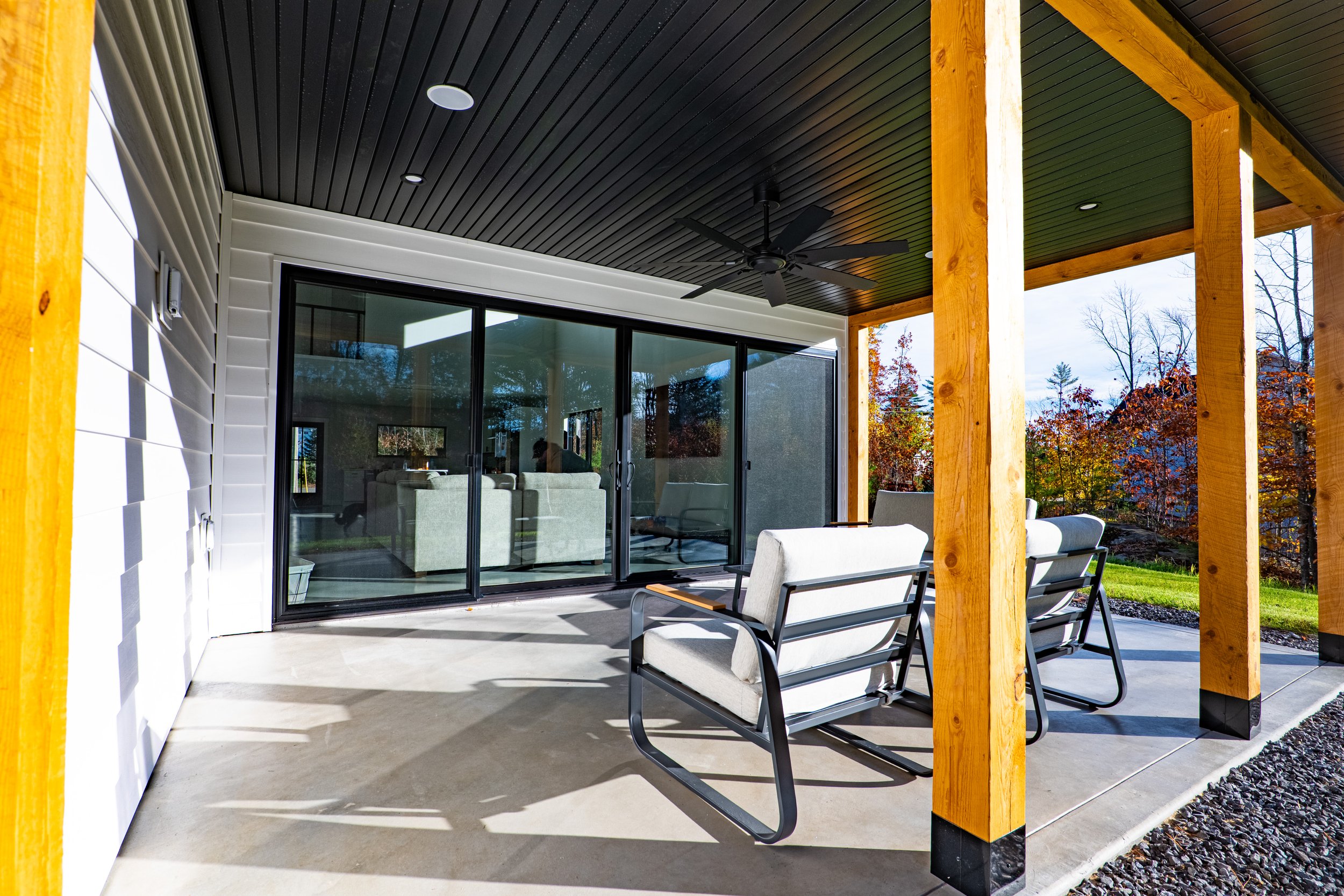 Covered back porch on custom Maine home
