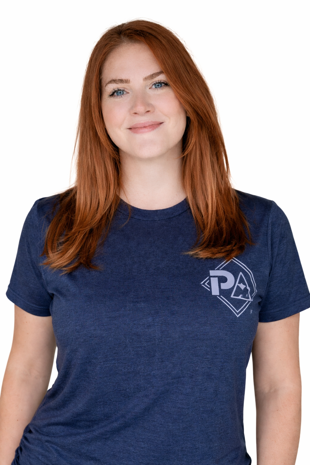 A woman with long red hair wearing a navy blue t-shirt with a logo on the chest, standing against a white background.
