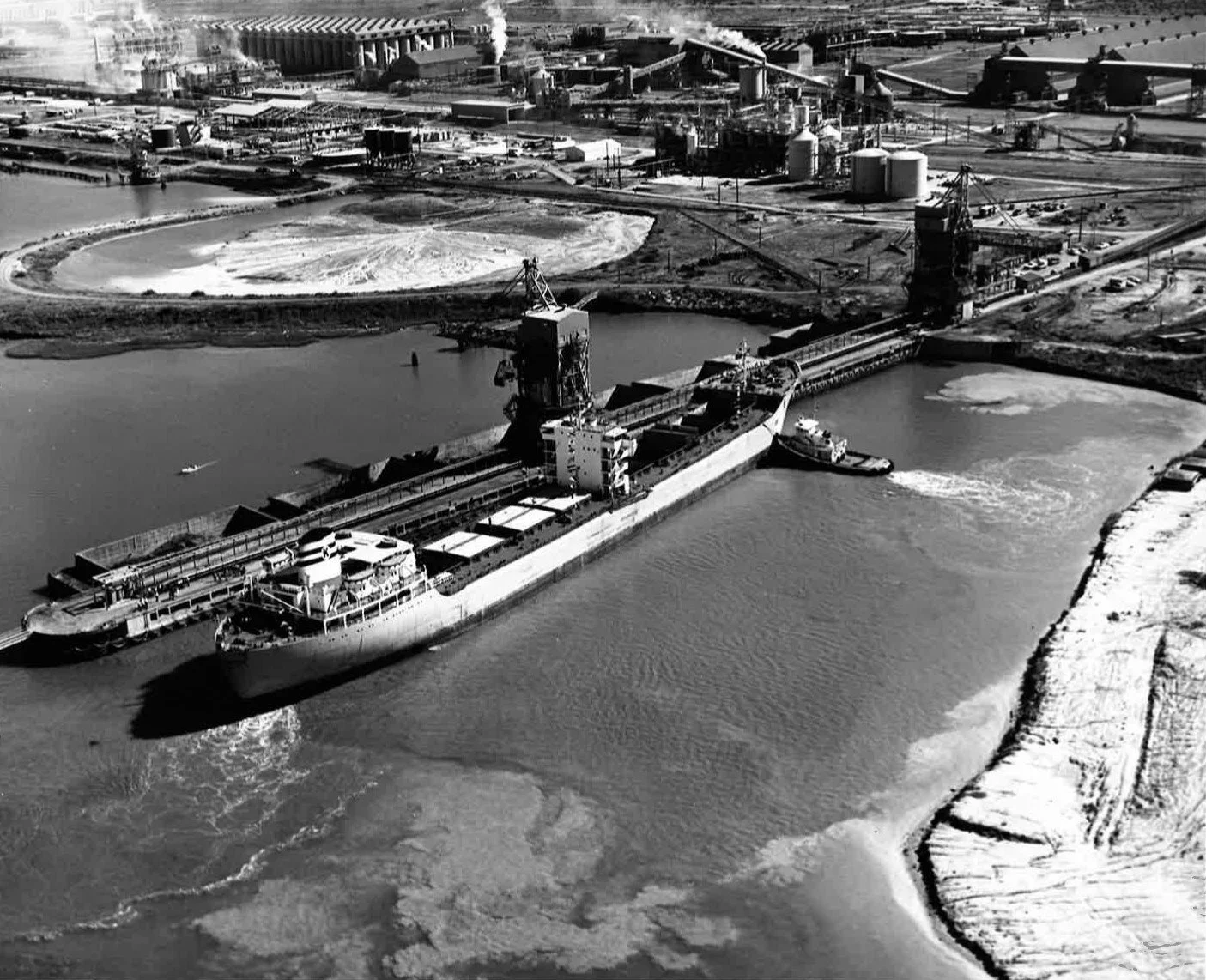 Black and white old photo at a port with a ship docked