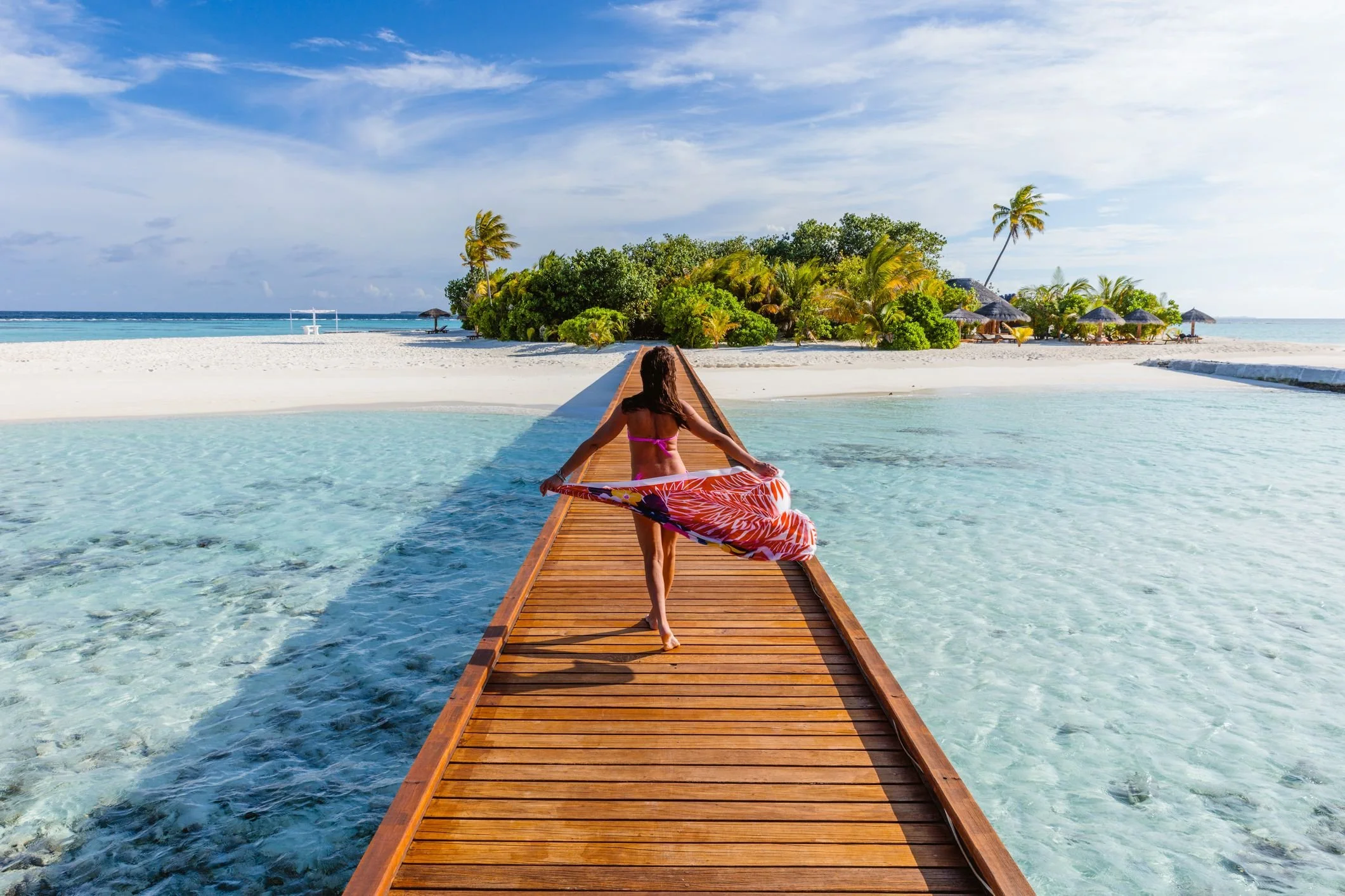 woman-with-sarong-walking-on-pier-maldives-royalty-free-image-1608667814_.jpg