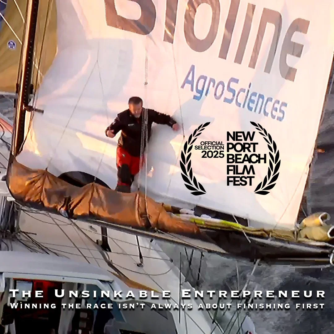 A person running on a boat during a sailing race, with a large sail displaying logos and banners from the New Port Beach Film Fest and AgroSciences, and a caption reading 'The Unsinkable Entrepreneur: Winning the Race Isn't Always About Finishing First.'