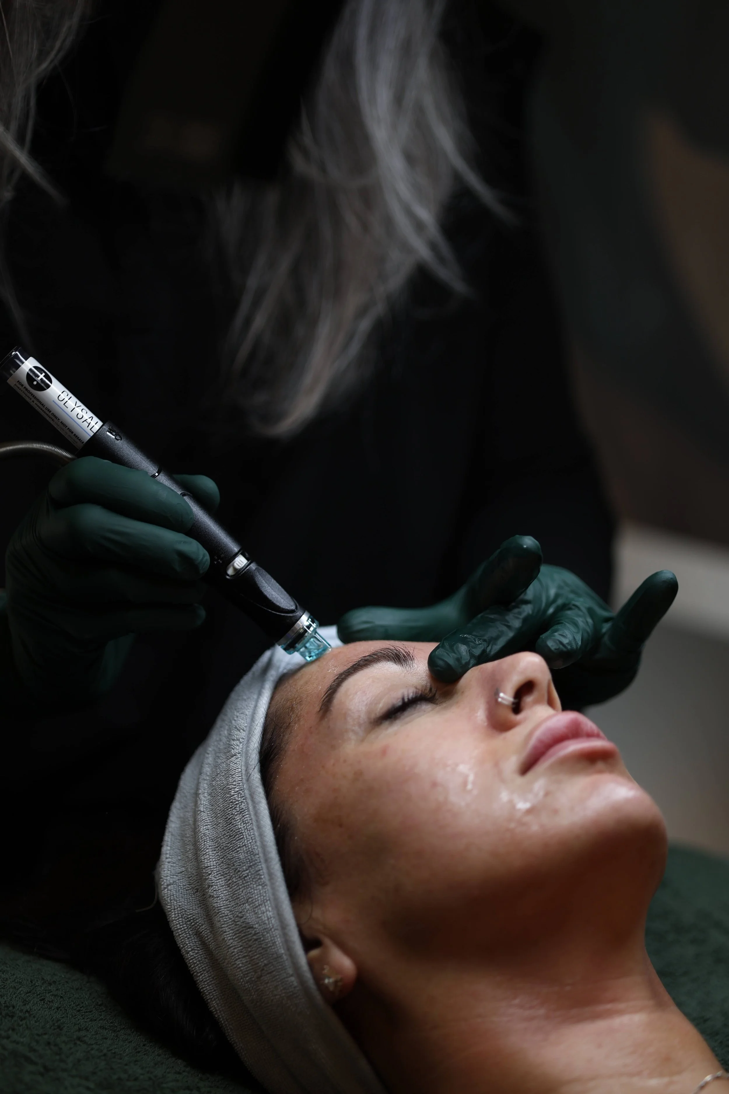 woman receiving a hydrafacial treatment from a bombshell aesthetics esthetician in Bedford nh 