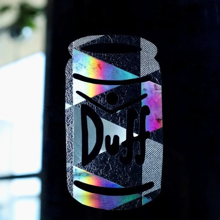 Fudd? No, you deserve a Duff!  Unique pattern of checkerboard of prismatic triangles will cast beautiful light and colors in your space that even Duffman would envy. Oh yeahhh!  Approximately 3”x5” and removable. Handmade in Toronto.