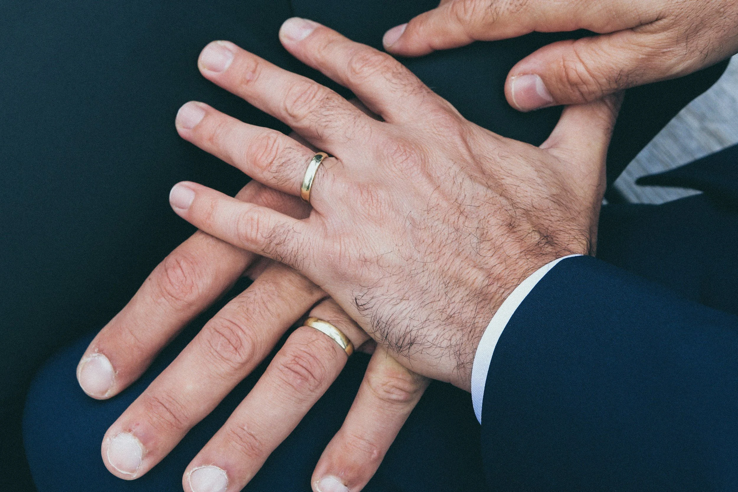Hands of same sex couple showing their wedding rings
