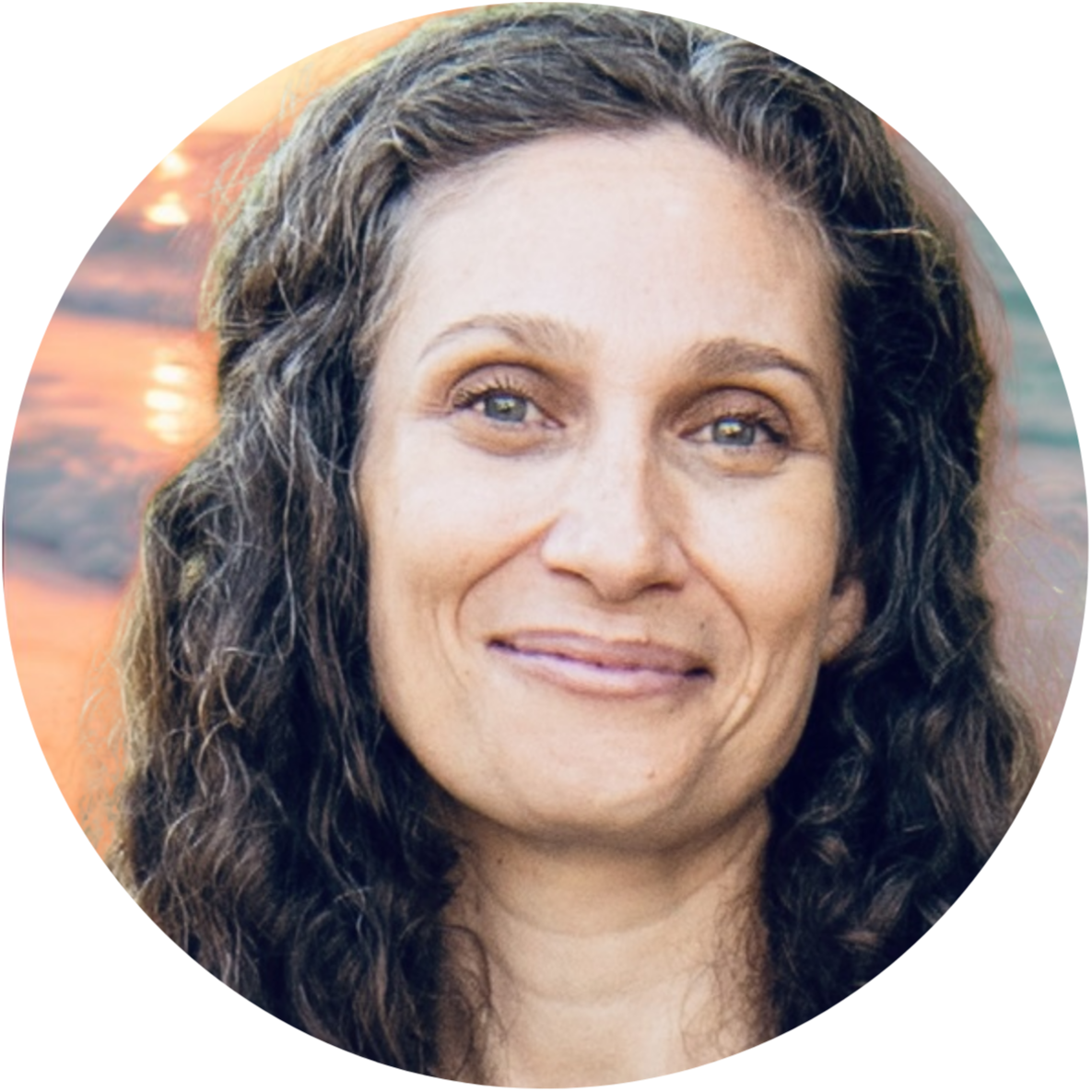 Woman smiling at sunset, representing hope and healing after trauma.