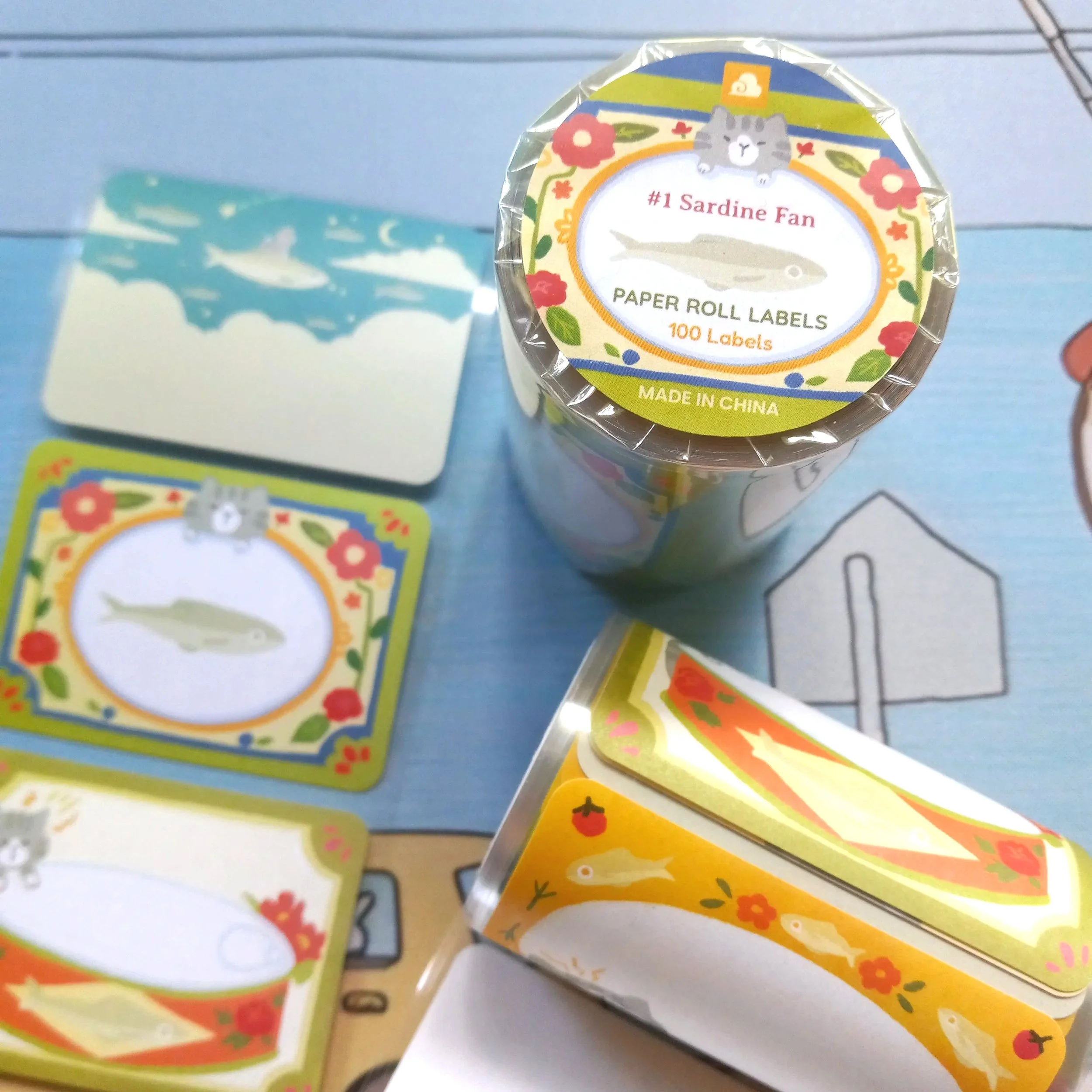 Paper roll label “#1 Sardine Fan” by Thousand Skies featuring playful cats with sardine illustrations