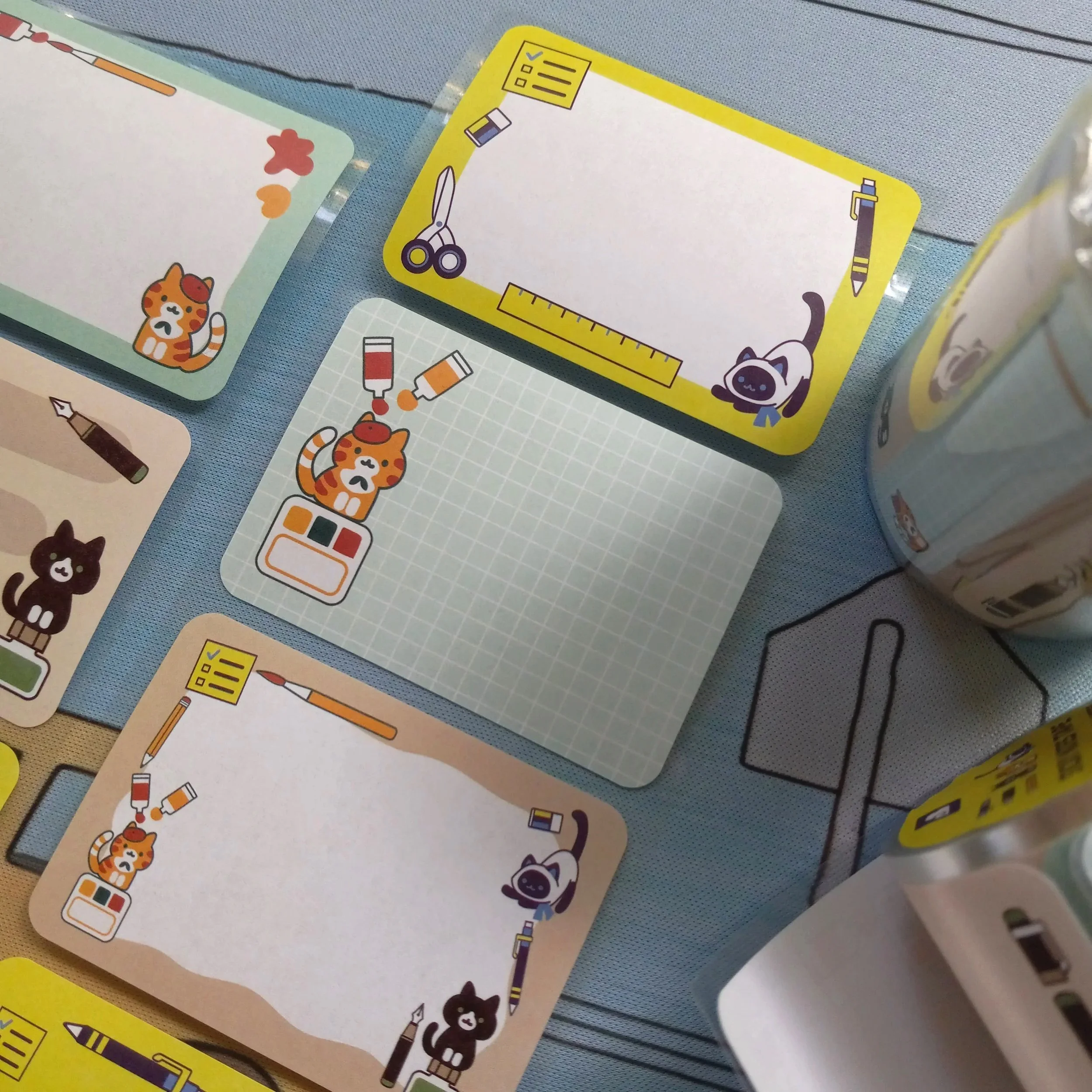 Close-up view of paper roll labels “Stationery Cats” showing whimsical cat designs with stationery motifs