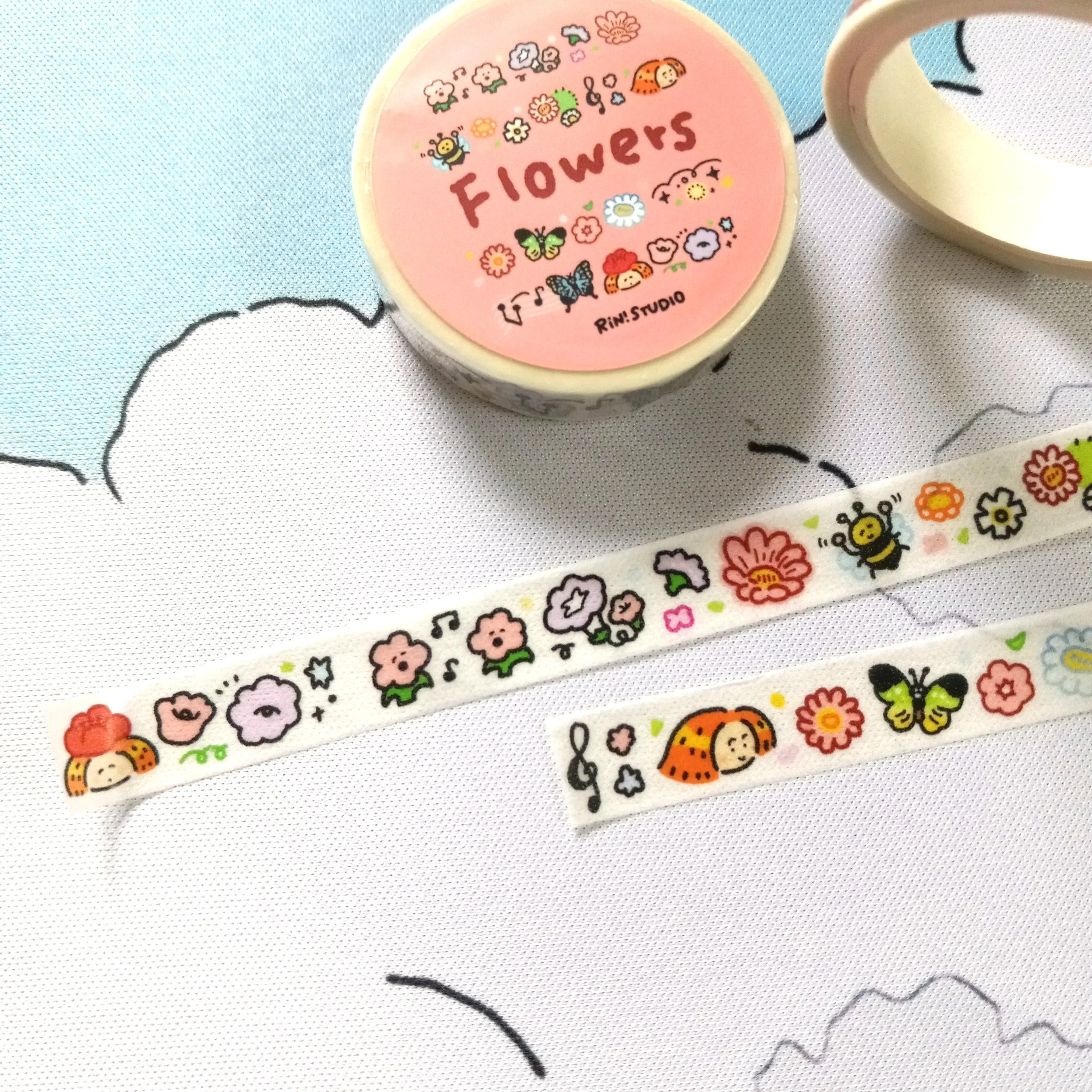 Mini washi tape roll with fun and colorful hand-drawn flower designs in a whimsical style by RiN! Studio