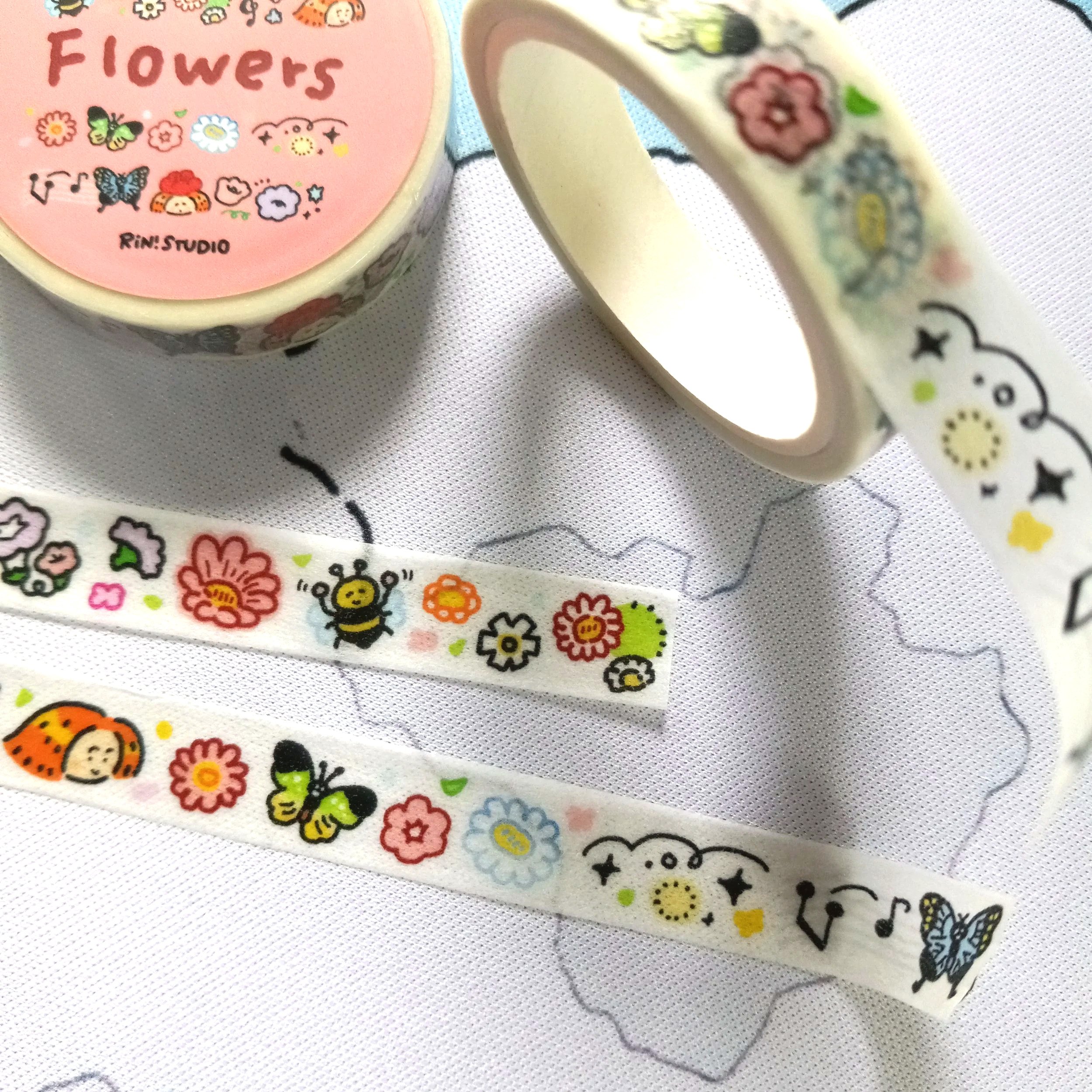 Mini washi tape roll featuring fun and vibrant illustrated flowers with a whimsical, playful aesthetic by RiN! Studio