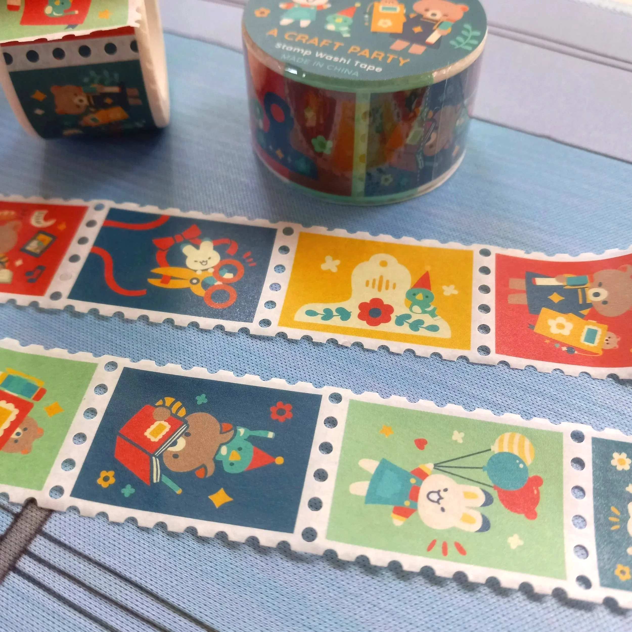 Close-up view of decorative stamp washi tape “A Craft Party” showing whimsical stationery and craft illustrations