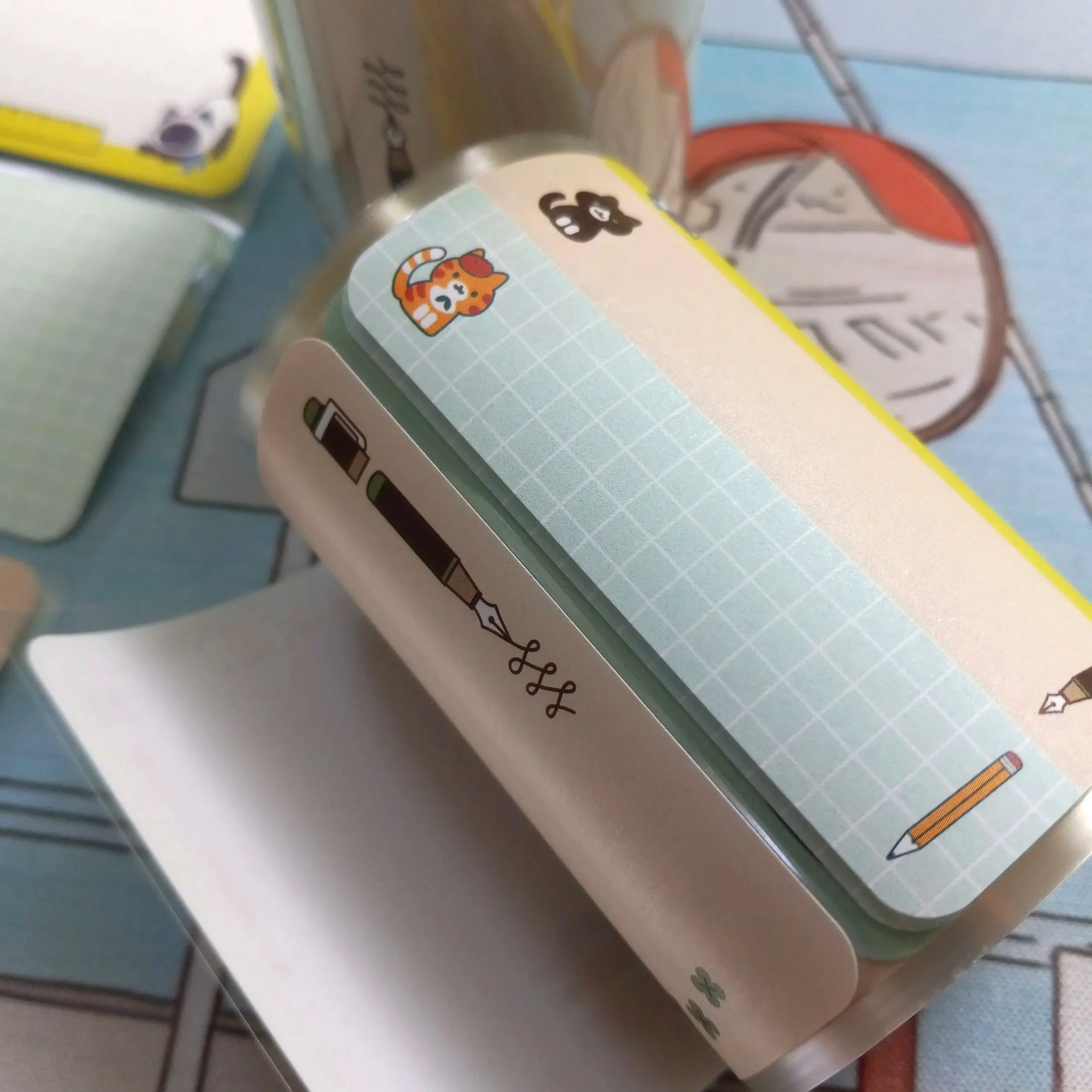 Macro detail of Thousand Skies paper roll label featuring cats interacting with pens, paper, and stationery items