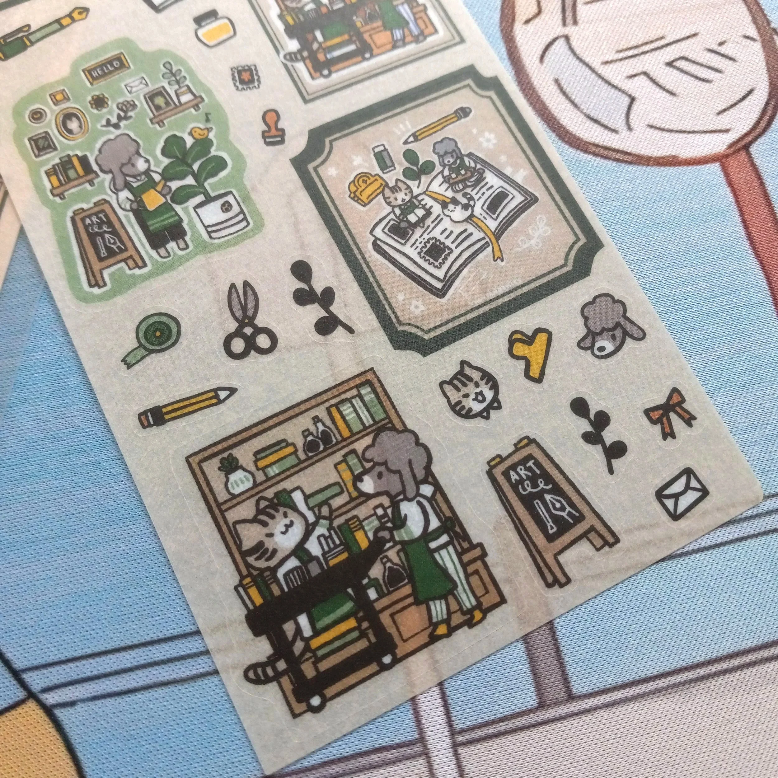Detailed close-up of “Stationery Store” washi sticker sheet with illustrated animal characters in a stationery store scene