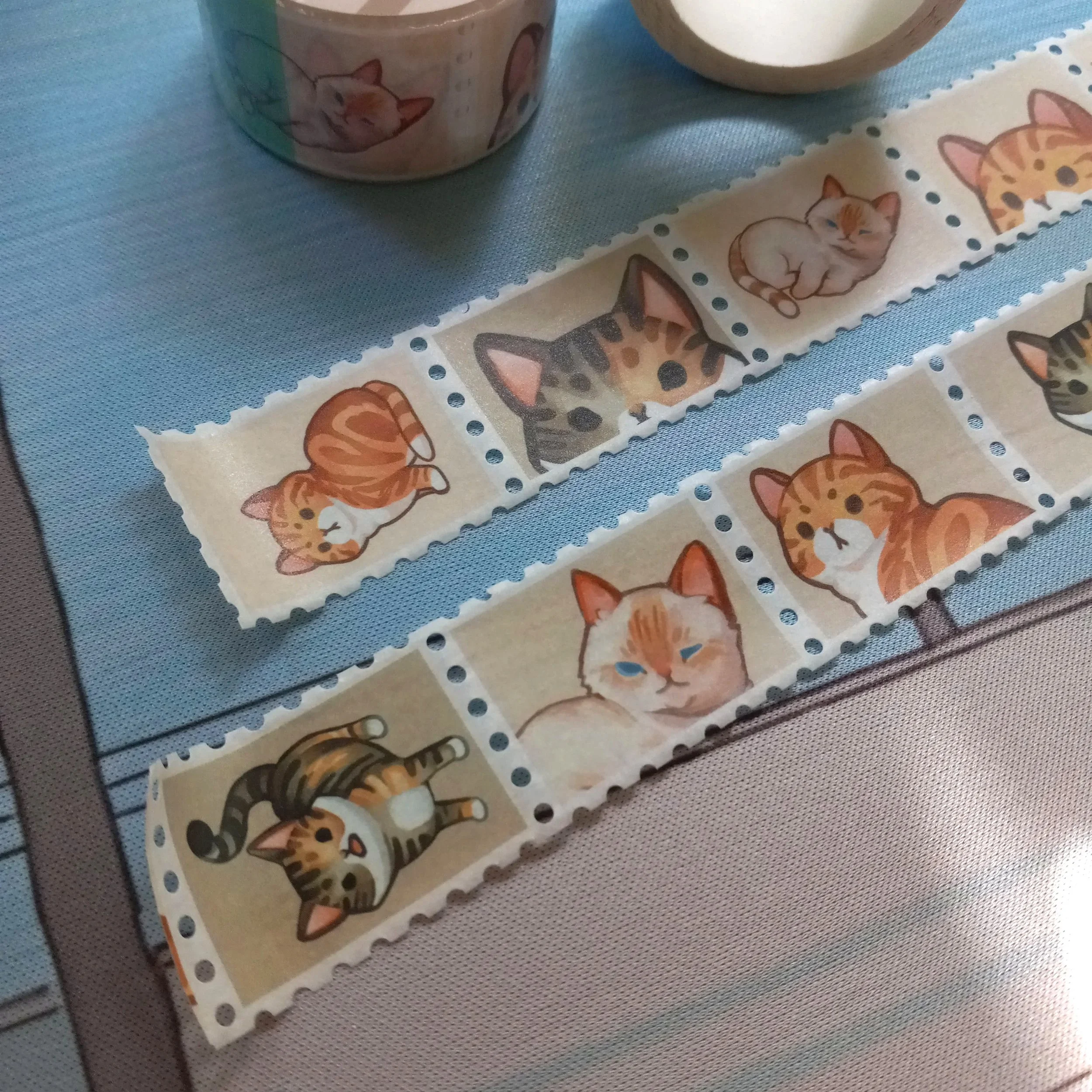 Close-up of stamp washi tape “Tabby Cats” showing repeating cat illustrations on a continuous decorative strip