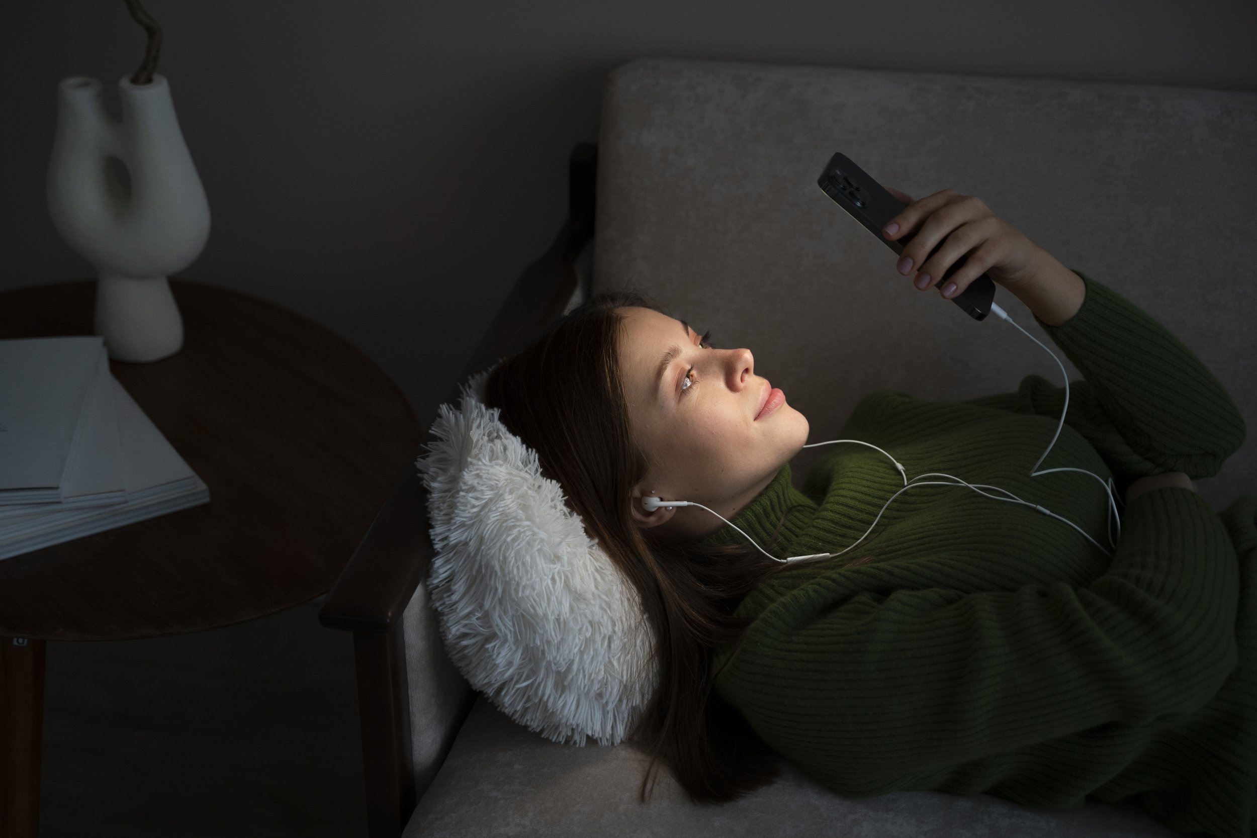 woman-listening-music-looking-her-smartphone-while-laying-bed.jpeg