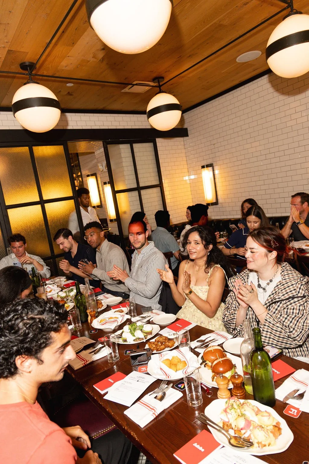 Guests gathered around a table, sharing a meal and applauding
