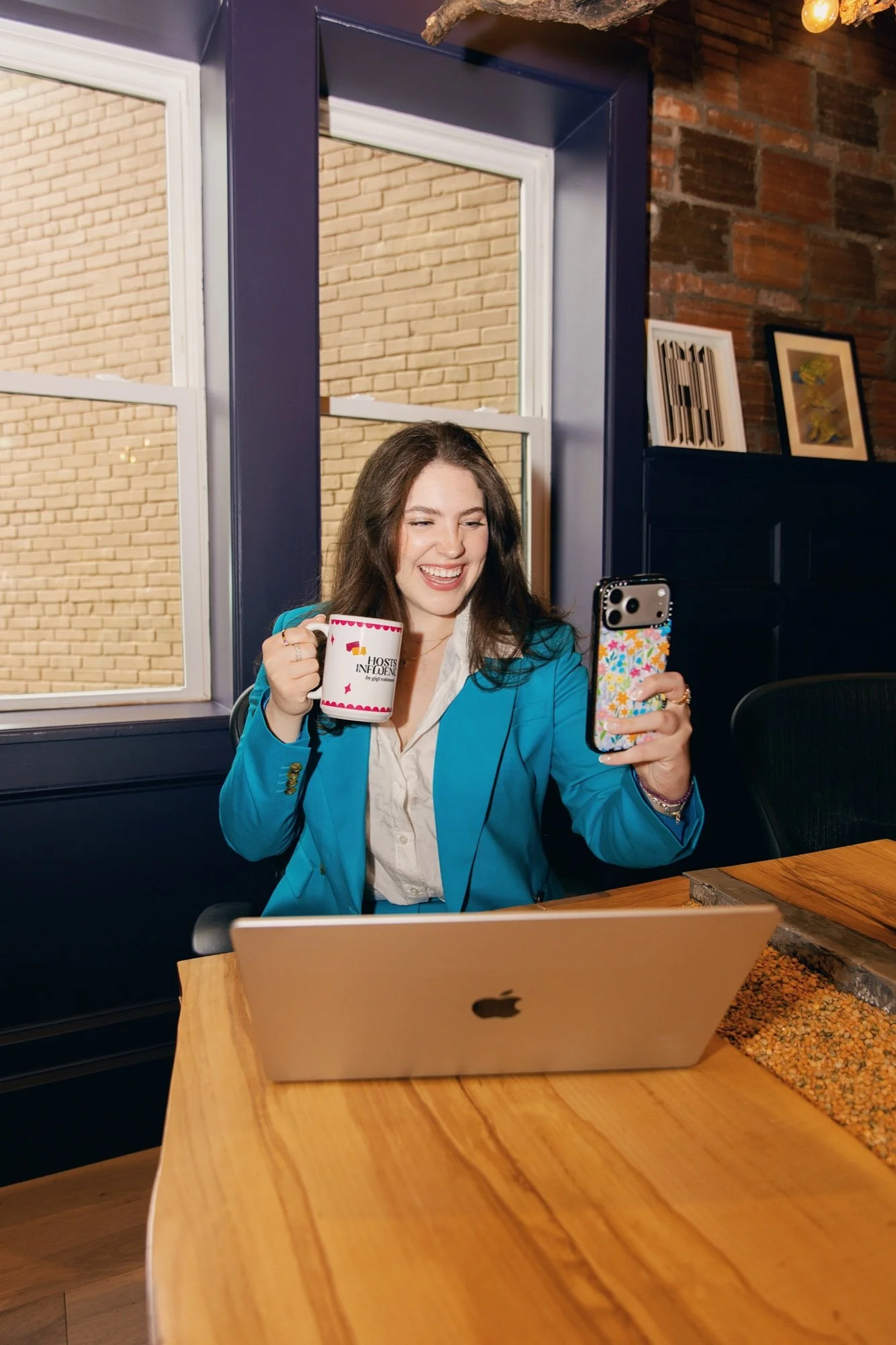 Gigi Robinson creating social content with her phone and laptop