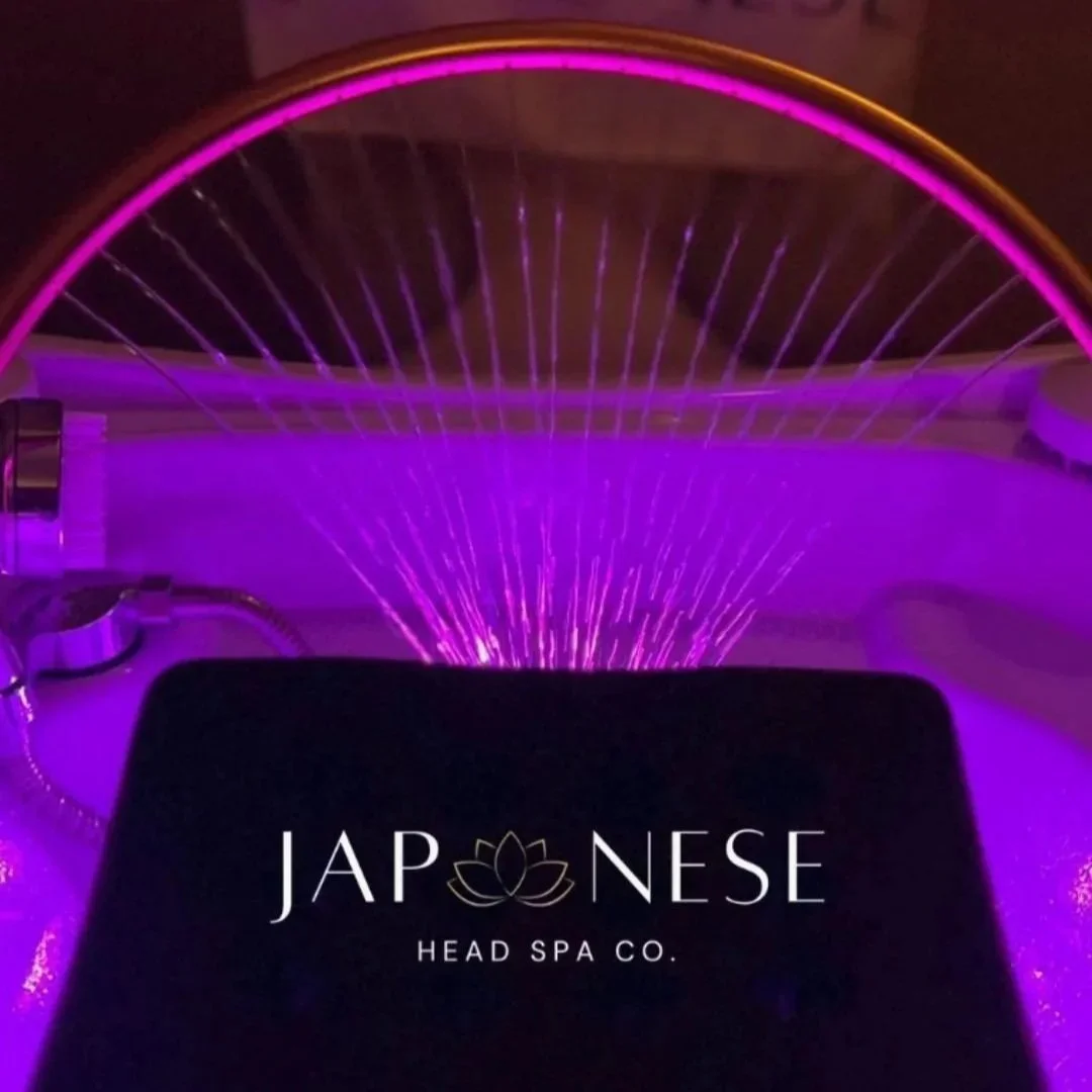 Spa pool with purple lighting and a fountain feature, with text overlay titled 'JAPONESE HEAD SPA CO.'