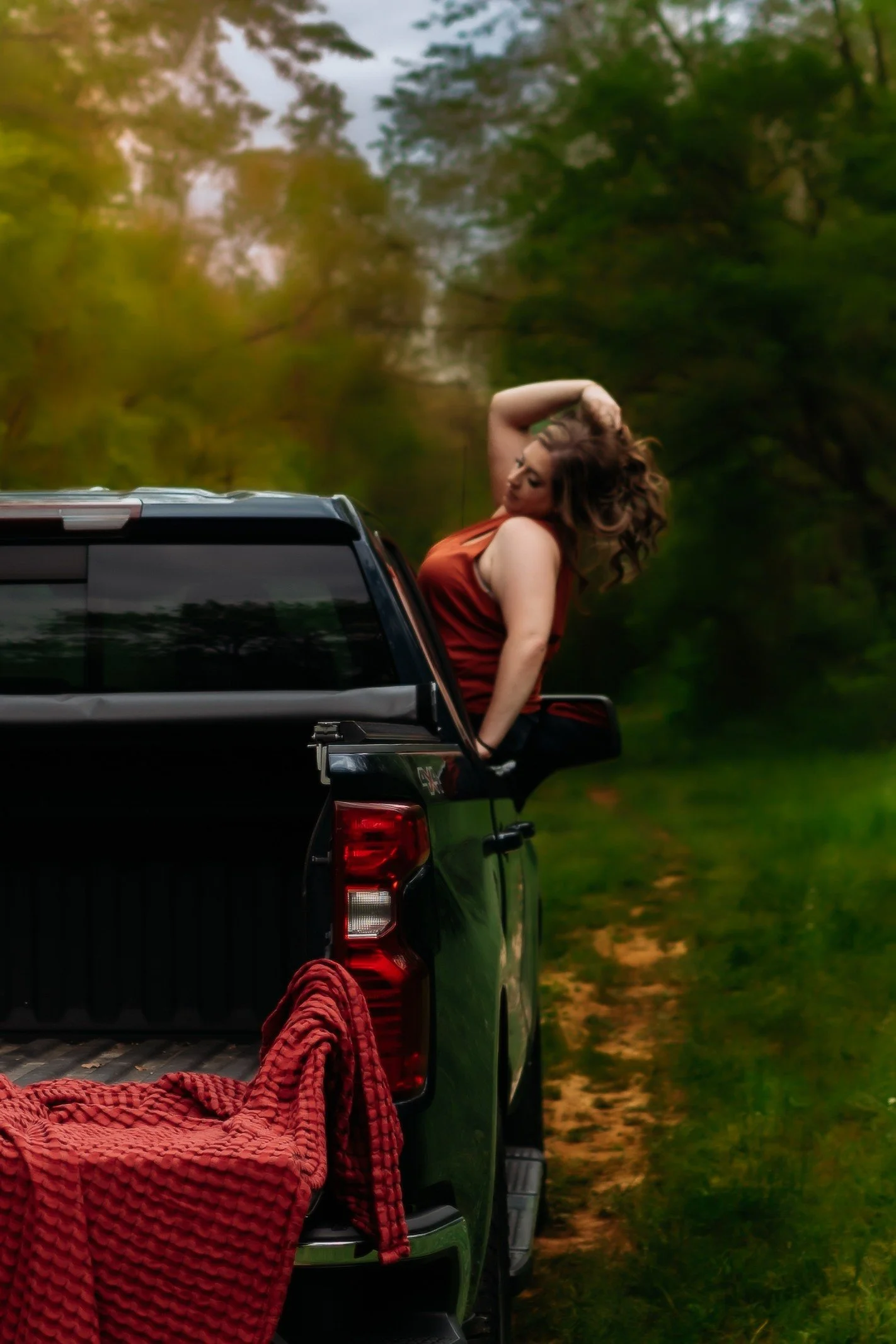 women sitting on the edge of the door out of the truck window holding her hair in clarksville tennessee