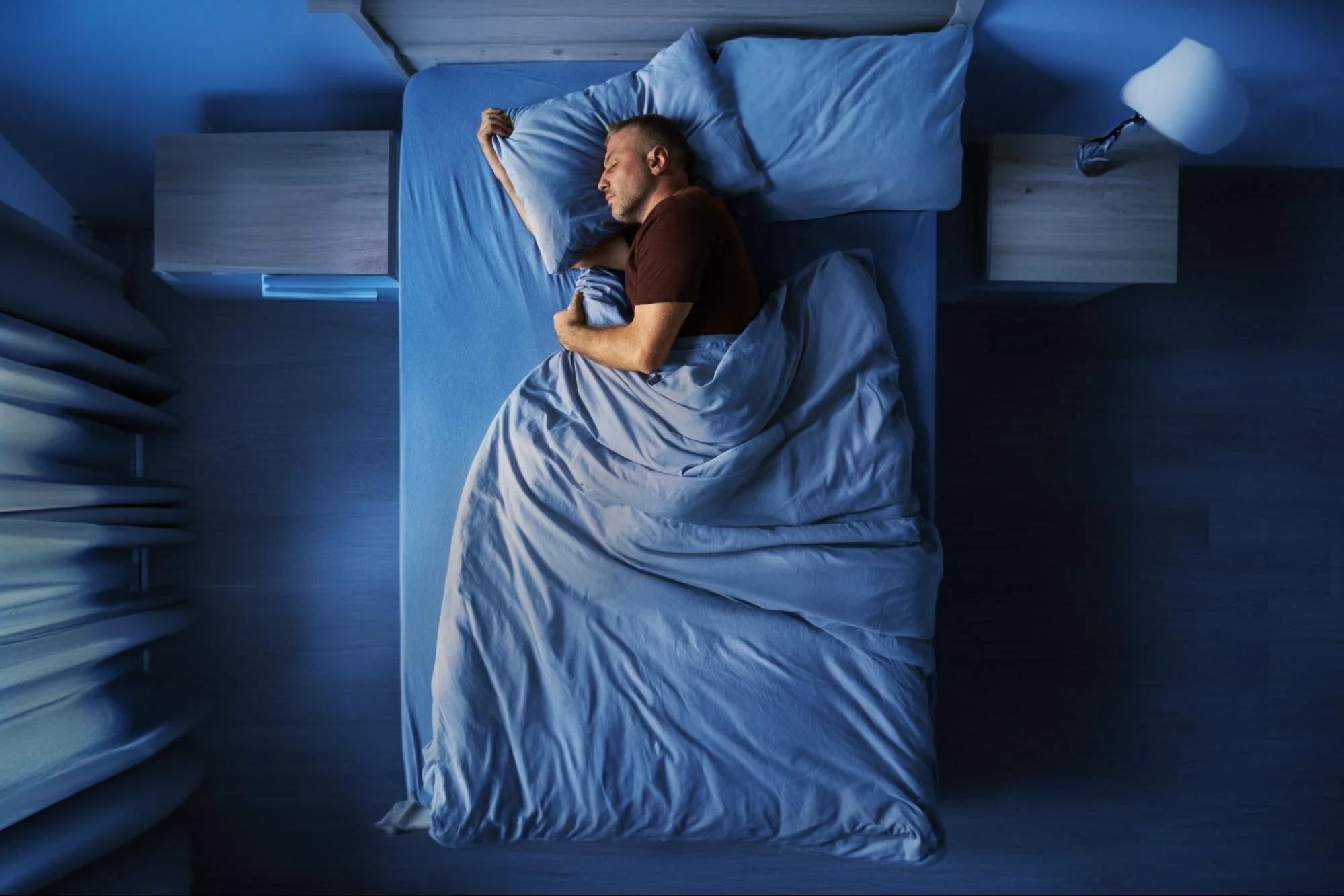 Top-down view of a man sleeping peacefully in a bed