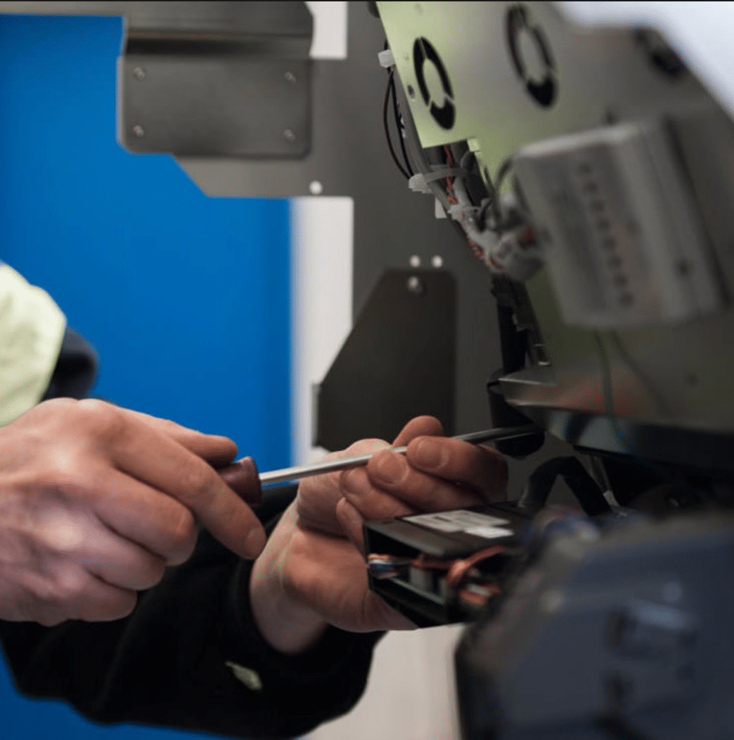 Technician repairing an ATM with tools