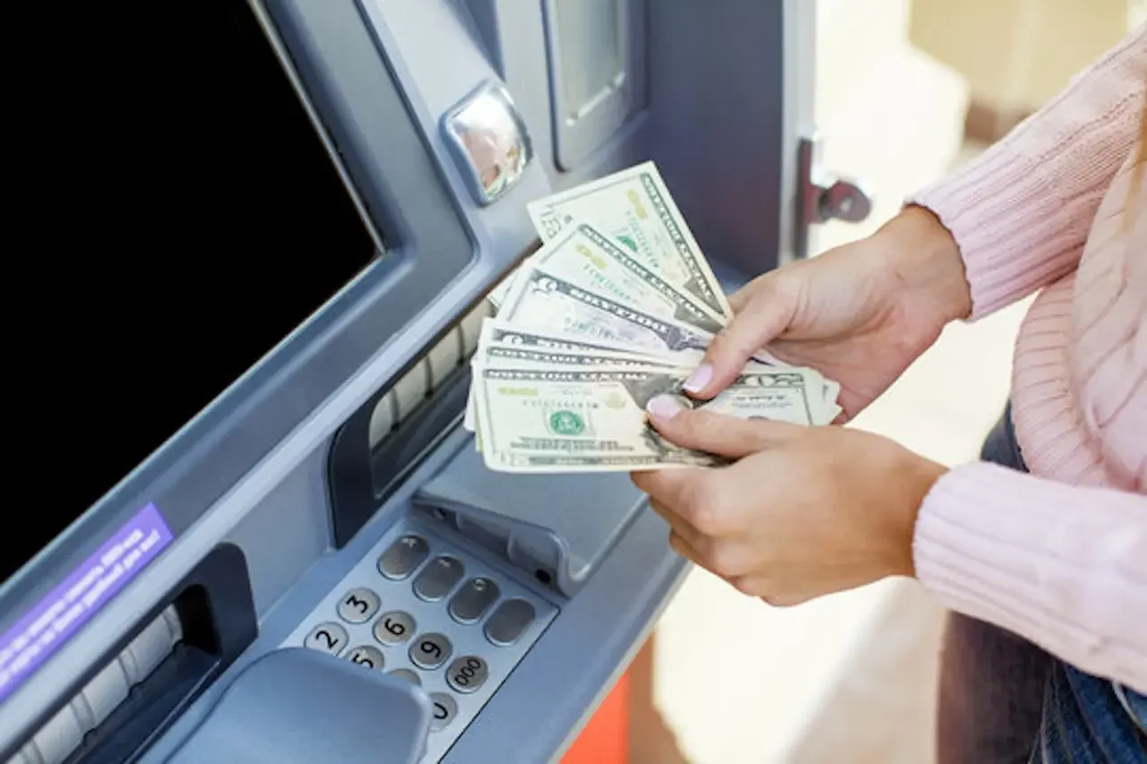 Business owner loading cash into an ATM machine for a merchant load partnership.