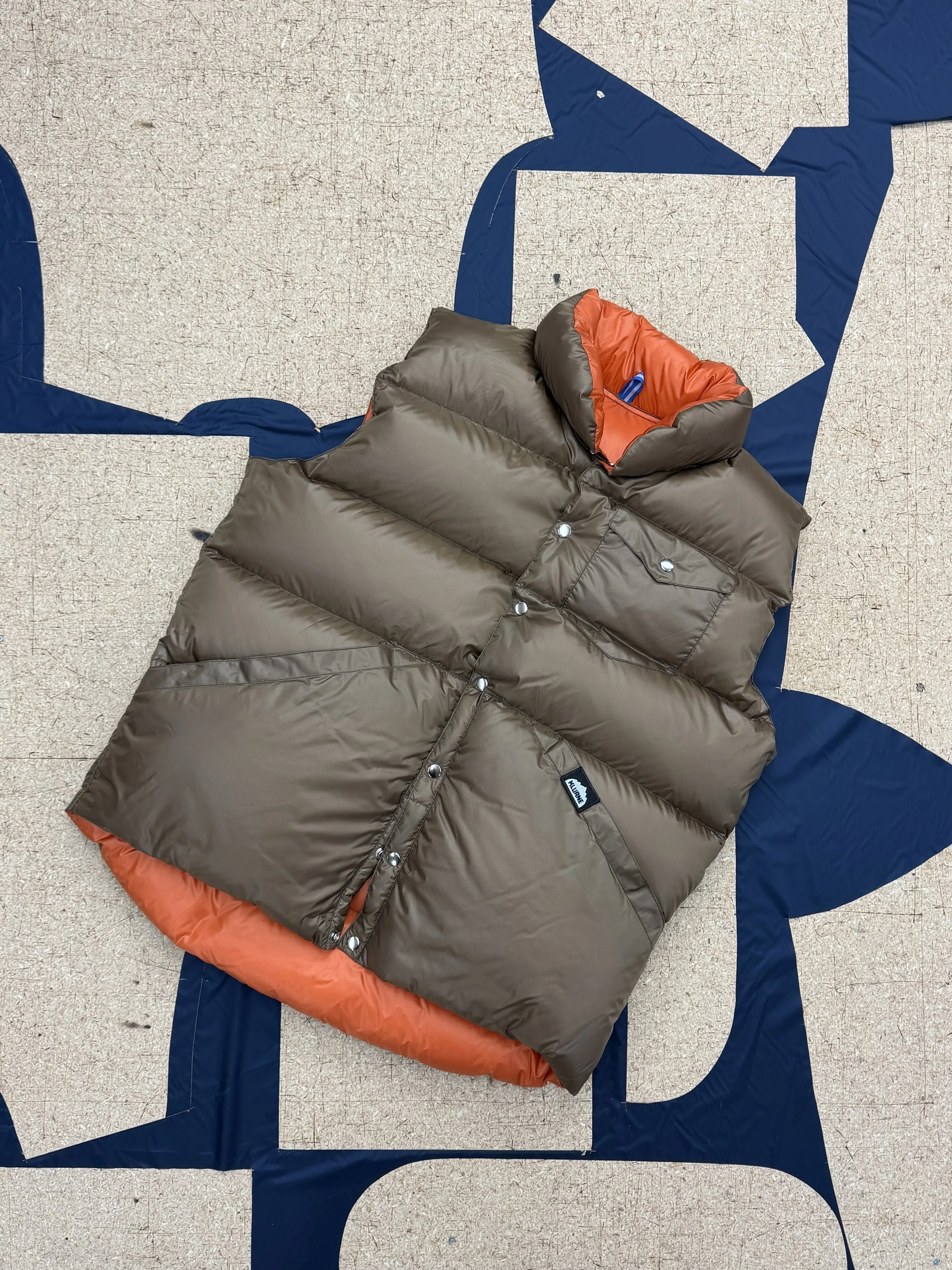 Kluane down vest on a cutting table with pattern pieces