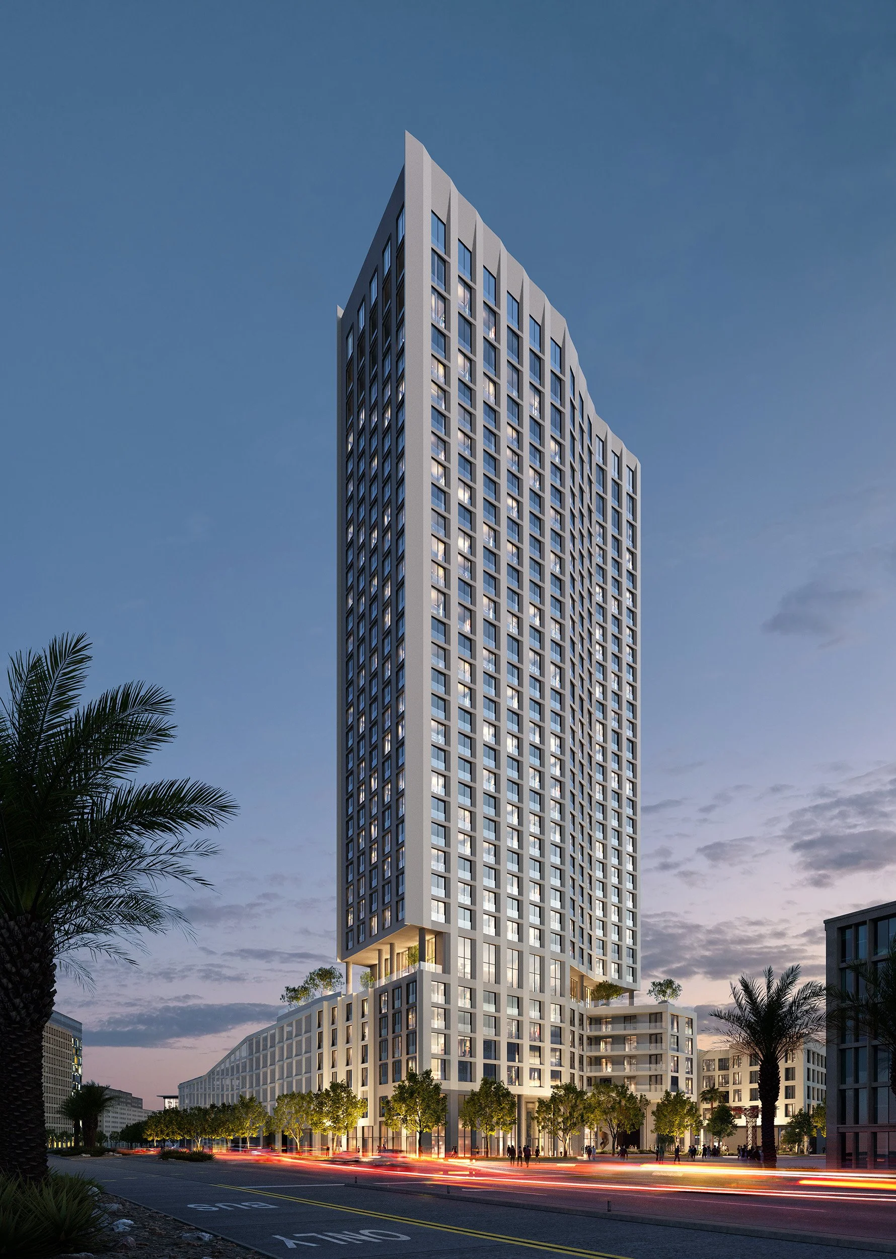 Tall modern high-rise building with numerous windows, set against a twilight sky, surrounded by palm trees and a busy street with car lights.