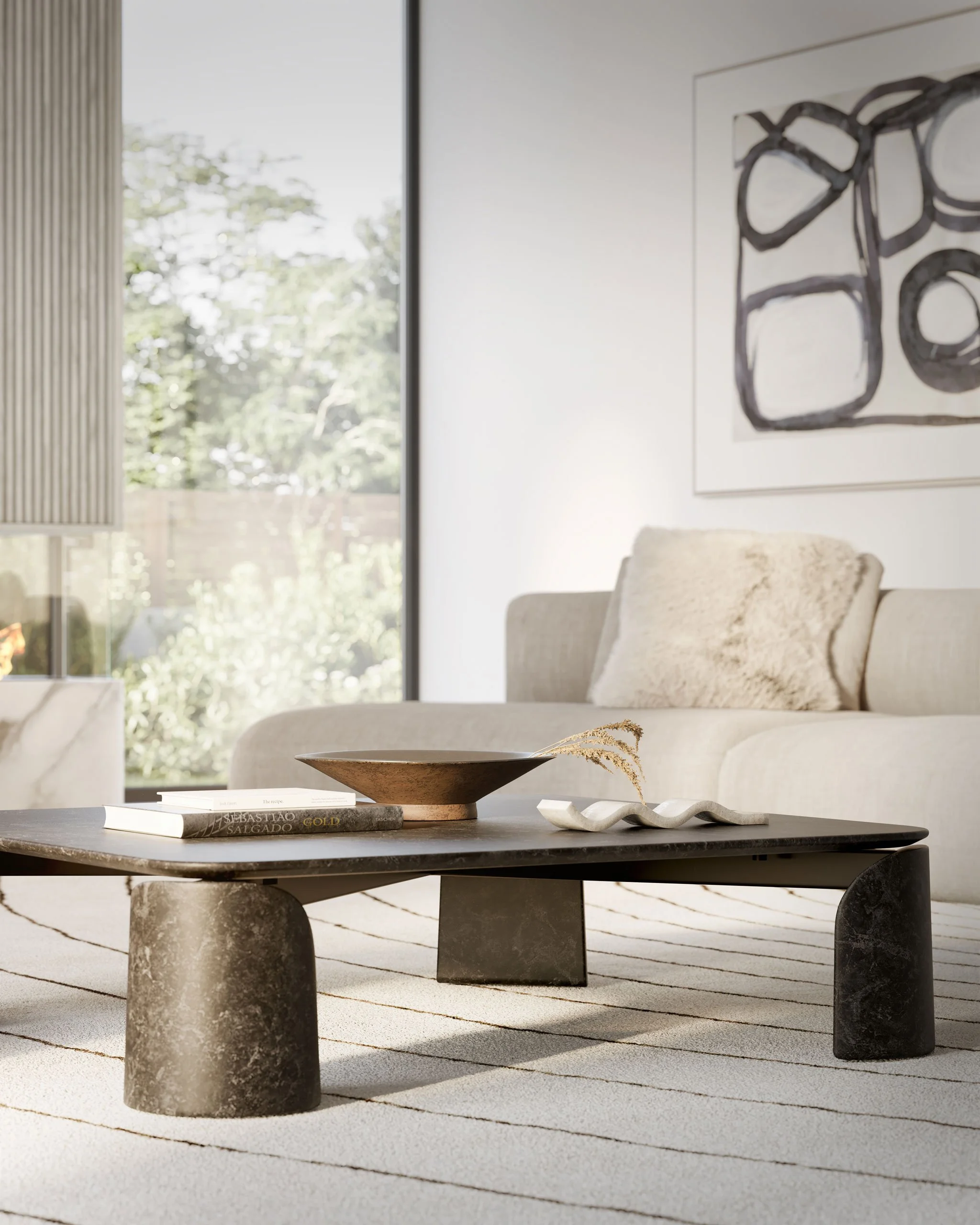 Modern living room with a low black coffee table, beige sofa with plush pillow, abstract wall art, and large window showing outdoor greenery.