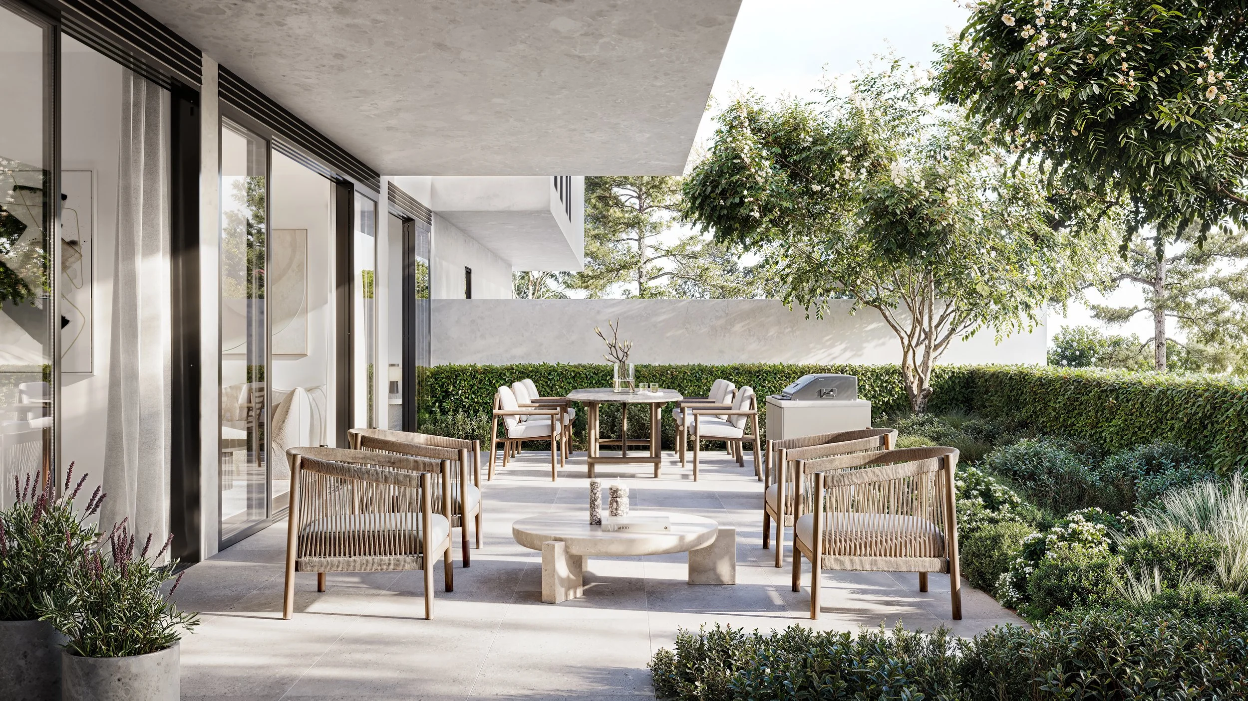 Modern outdoor patio with patio furniture, glass sliding doors, and surrounding greenery, including trees and shrubs.