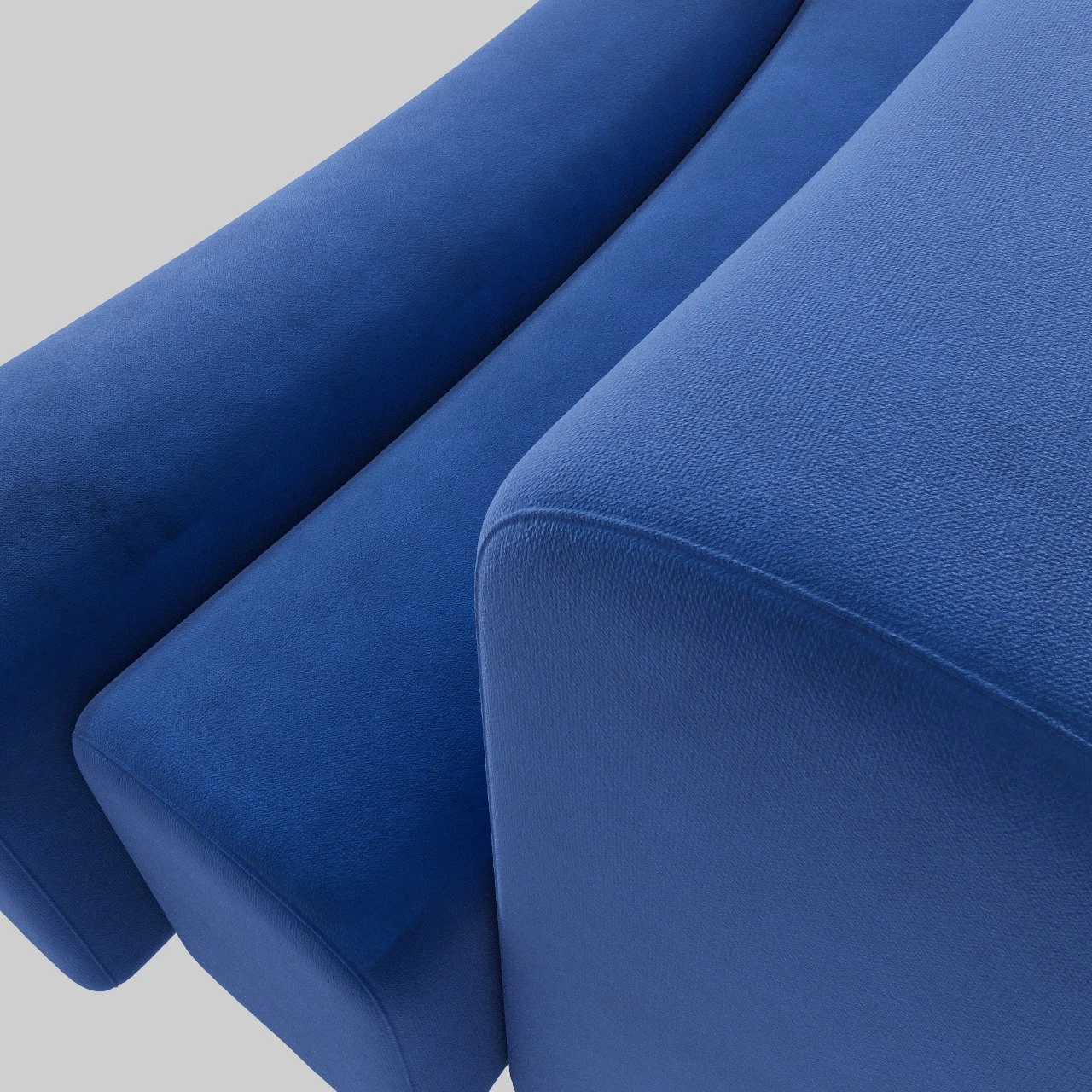 Close-up of a blue upholstered sofa with textured fabric and a rounded armrest.