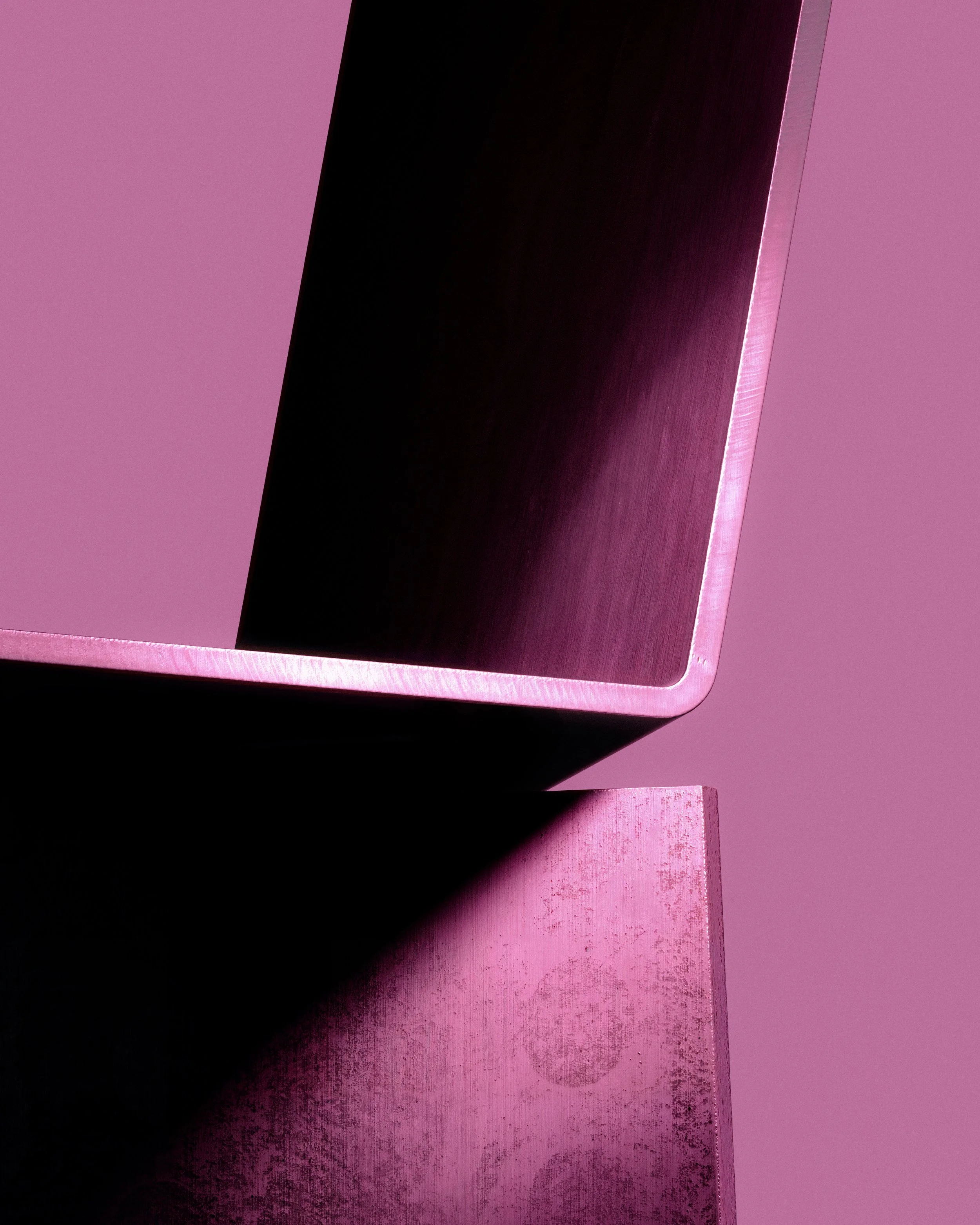 Abstract close-up of a sculptural chair, highlighting geometric edges, material surfaces, and soft magenta lighting in a minimal design study. LOES BETA GMBH