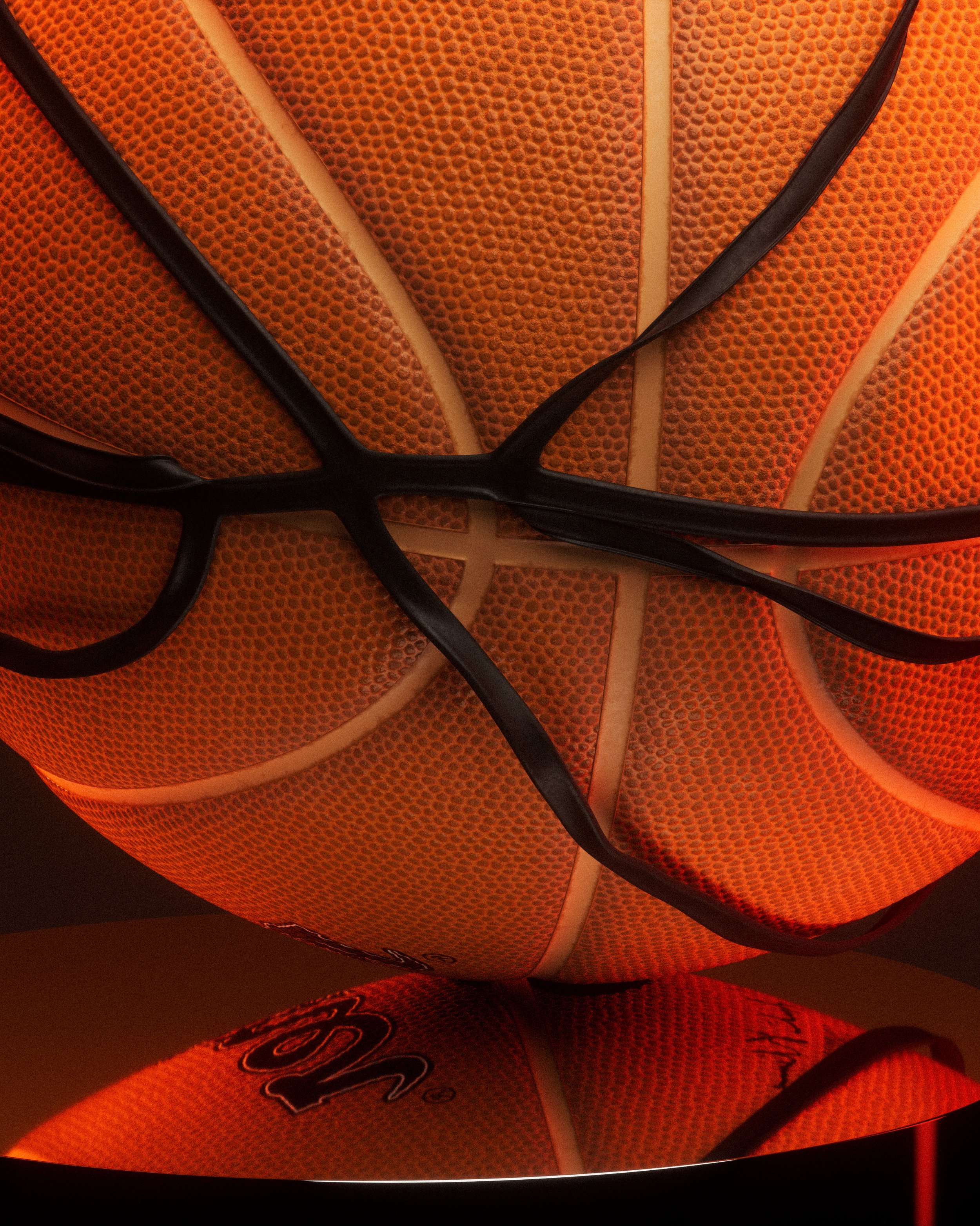 A basketball rests on a minimalist pedestal, illuminated from below to create a warm glow and accentuate the texture and form of the ball.