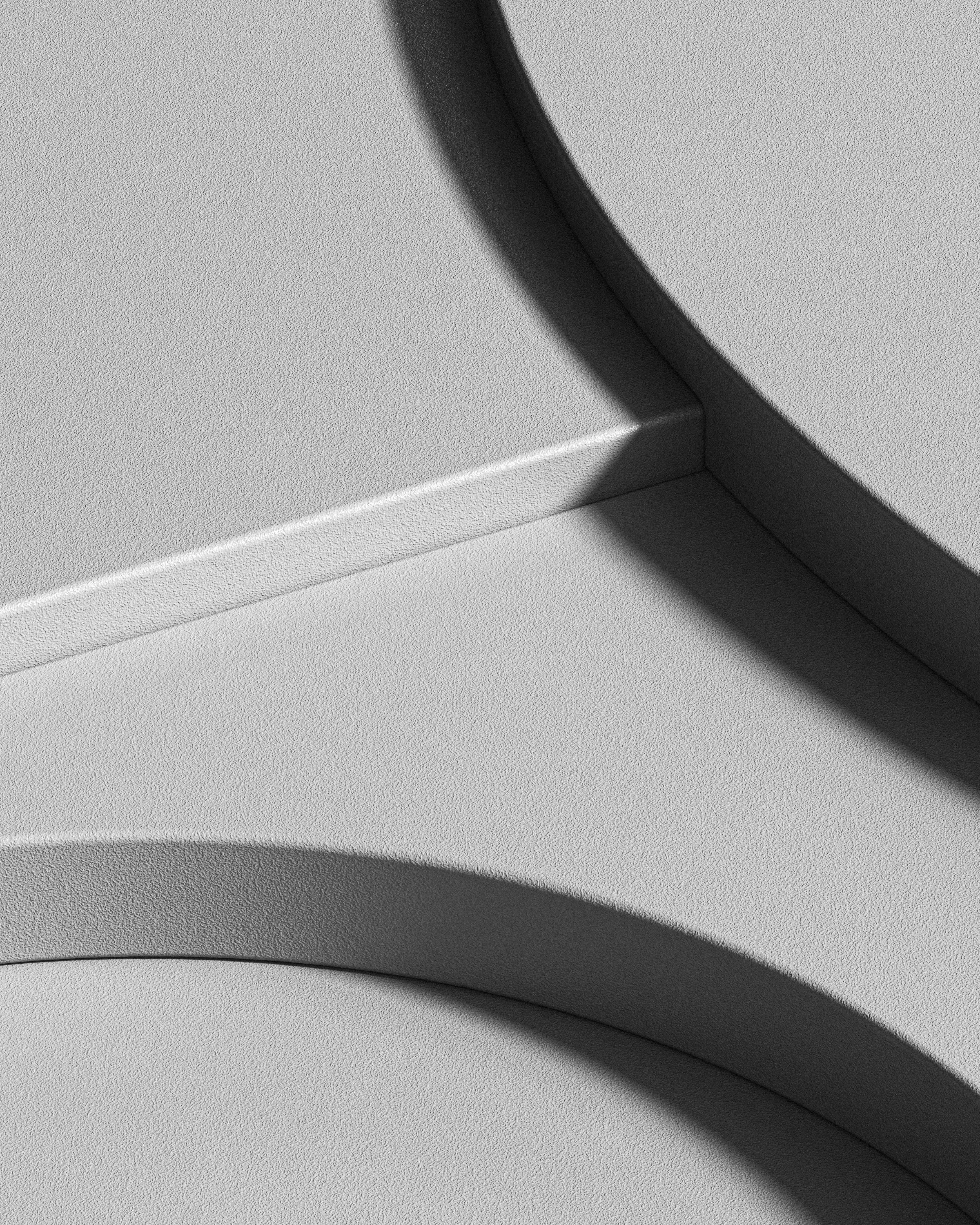 Close-up of a textured, light-colored, modern architectural corner with smooth, rounded and angular edges and shadows.