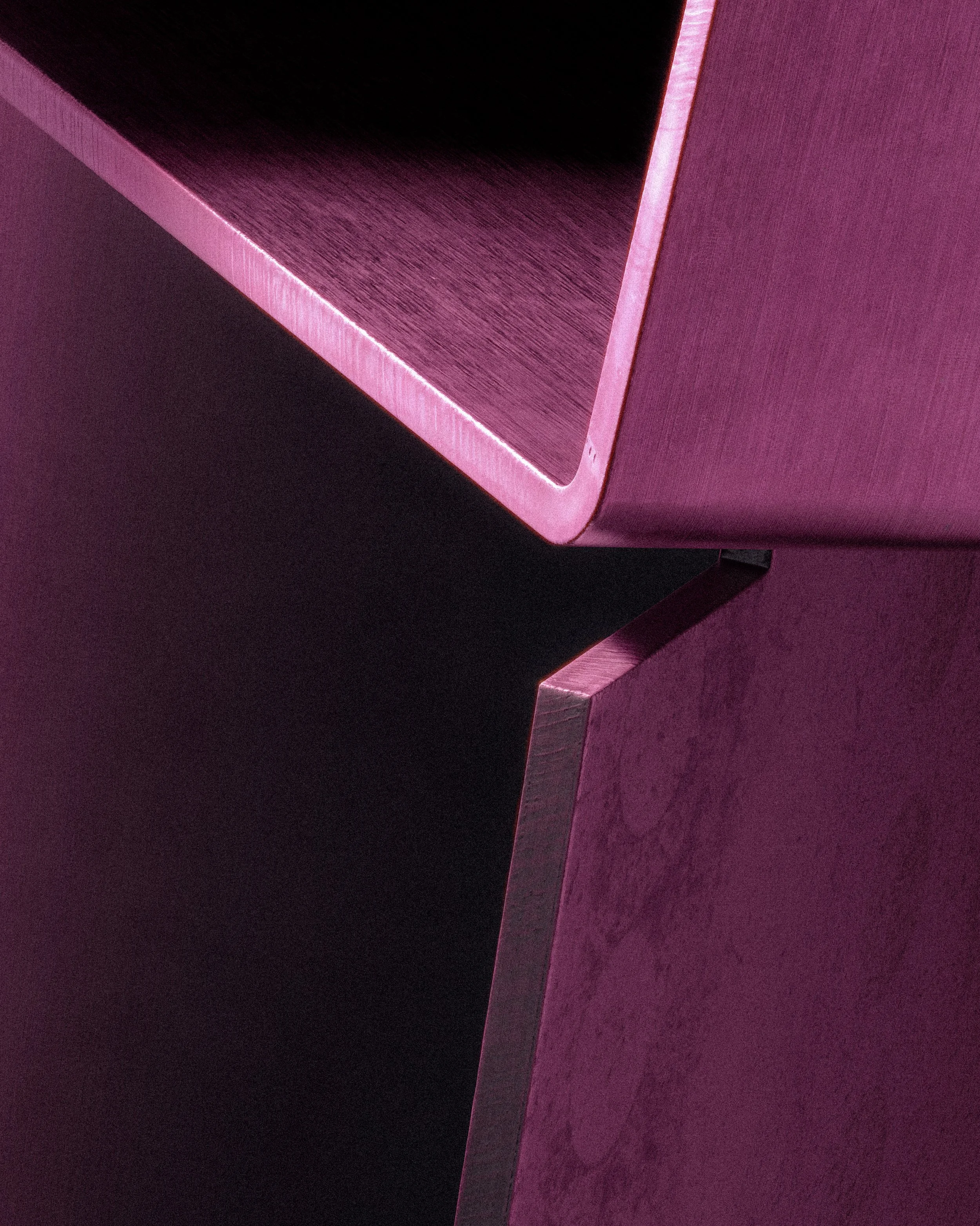 Abstract close-up of a sculptural chair, highlighting geometric edges, material surfaces, and soft magenta lighting in a minimal design study. LOES BETA GMBH