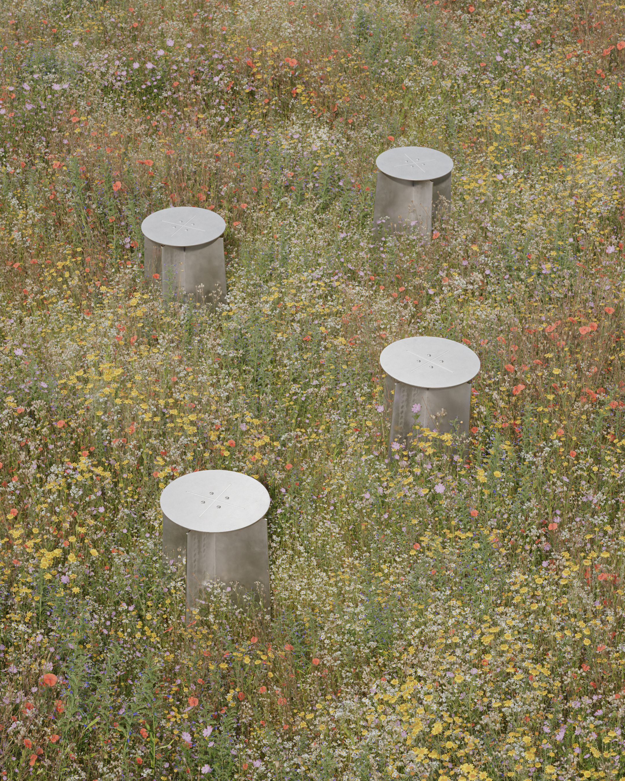Four metallic stools standing amidst a colorful wildflower field. LOES BETA GMBH